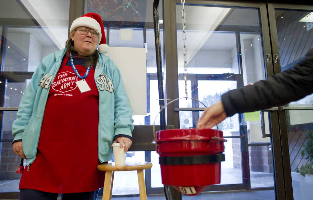 Salvation Army bell ringer Mary Ferrill watches as a Juneau resident makes a contribution at the Nugget Mall on Friday, Dec. 16, 2016. Ferrill said, "This is where my heart is during Christmas time. I did this last year and had a ball and I am having a ball this year. I get to get out in the community and talk to people. Merry Christmas."
