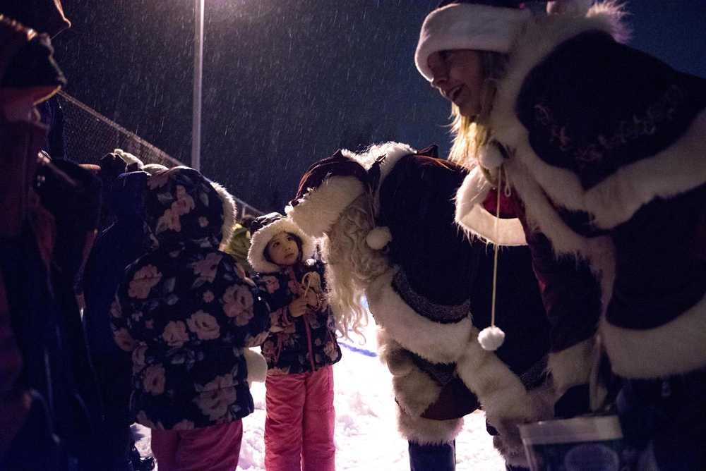 Savana Martinez, 4, speaks to firefighter EMT Steve Anderson, dressed as Santa Clause, as firefighter EMT Kristi Asplund, dressed as Mrs. Clause, talks with other children during Santa's Annual Ride with Capital City Fire/Rescue in the Mendenhall Valley at Glacier Valley Elementary School on Dec. 17, 2016. Santa's ride went throughout the Mendenhall Valley, and Capital City Fire/Rescue volunteers handed out candy canes. (Photo by Marlena Sloss).