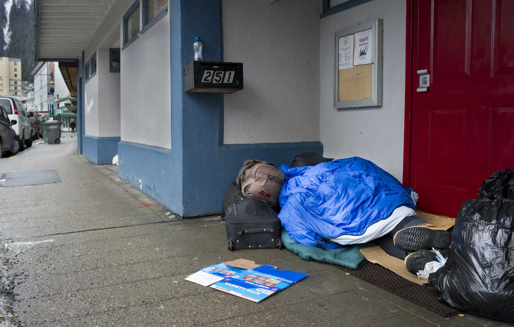 A homeless man sleeps in the doorway of the Filipino Community Hall on Wednesday, Dec. 21, 2016.