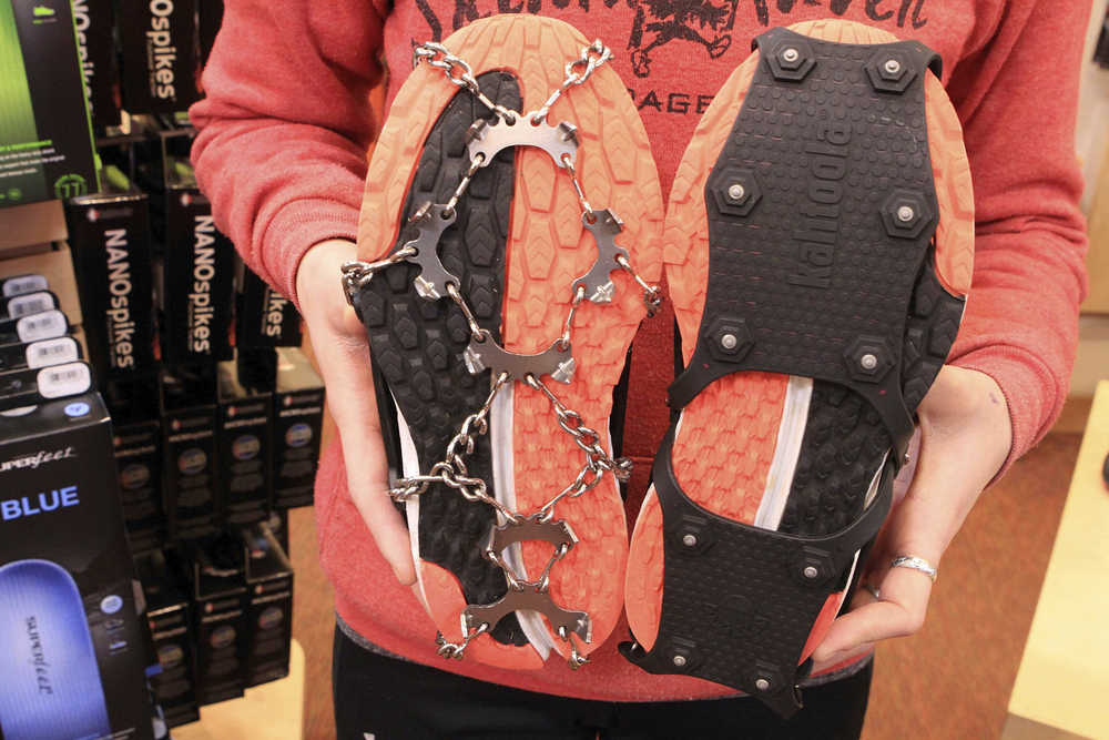In this Nov. 29, photo Emma Bohman, a sales associate at Skinny Raven sporting goods in Anchorage, shows two kinds of exterior cleats attached to running shoes.