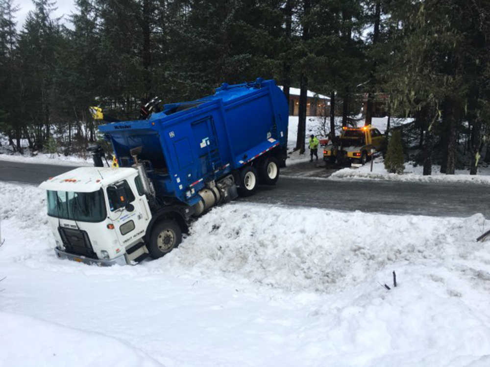 A garbage truck is pulled out of the snow after it slid off View Drive on Dec. 20.