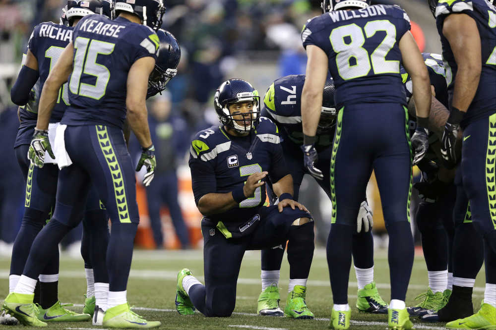 Seattle Seahawks quarterback Russell Wilson (3) talks with teammates in a huddle on Dec. 24 during a game against the Arizona Cardinals in Seattle.