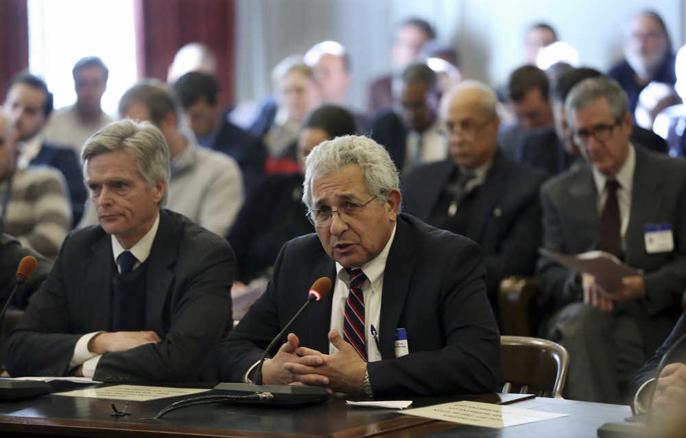 FILE - In this Dec. 15, 2016 file photo, Stephen W. Parker, left, co-owner and co-publisher of New Jersey Hills Media Group, listens as Richard Vezza, publisher of the Star-Ledger newspaper, addresses members of the New Jersey Assembly Appropriations Committee, as the committee considers among others, legislation to scrap a requirement that legal notices be published in newspapers, after a Senate budget committee greenlighted the legislation earlier in the day, in Trenton. As classified advertising, once the lifeblood of newspapers, has dried up, one constant has remained: A thick daily listing of government public notices. But legislative fights in New Jersey and elsewhere have put that tradition at risk. (AP Photo/Mel Evans, File)