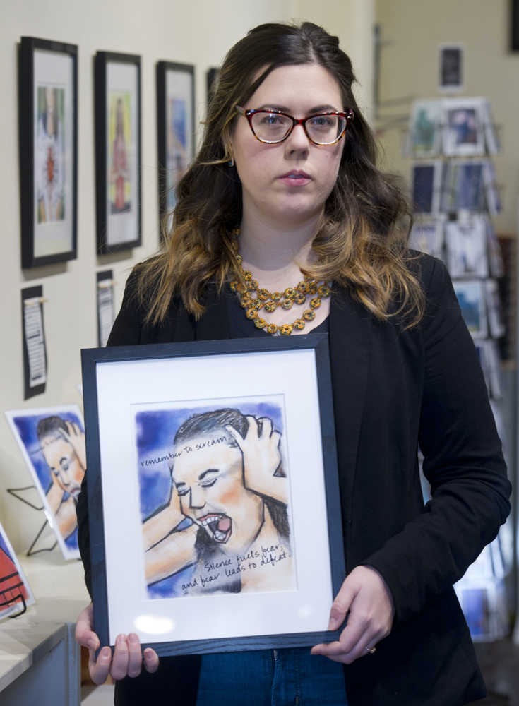 Christine Carpenter holds one of her artworks in the Alaska Robotics Gallery on Friday, Jan. 6, 2017, she made after being raped in Italy.