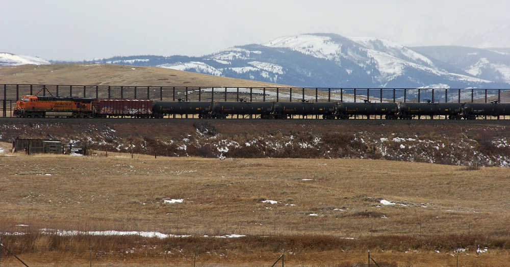 In this Nov. 7, 2013 photo, a train hauls oil into Glacier National Park near the Badger-Two Medicine National Forest in northwest Montana. The Interior Department has canceled the final two oil and gas leases in a wilderness area bordering Glacier National Park that's sacred to the Blackfoot tribes of Montana and Canada.