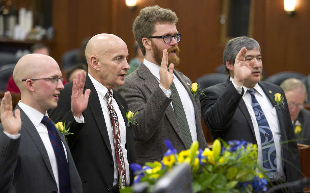 Rep. Jonathan Kreiss-Tomkins, D-Sitka, left, Rep. Dan Ortiz, I-Ketchikan, Rep. Justin Parish, D-Juneau, and Rep. Sam Kito, D-Juneau, are sworn-in by Lt. Gov. Byron Mallott on the first day of the first session of 30th Alaska Legislature at the Capitol on Tuesday.