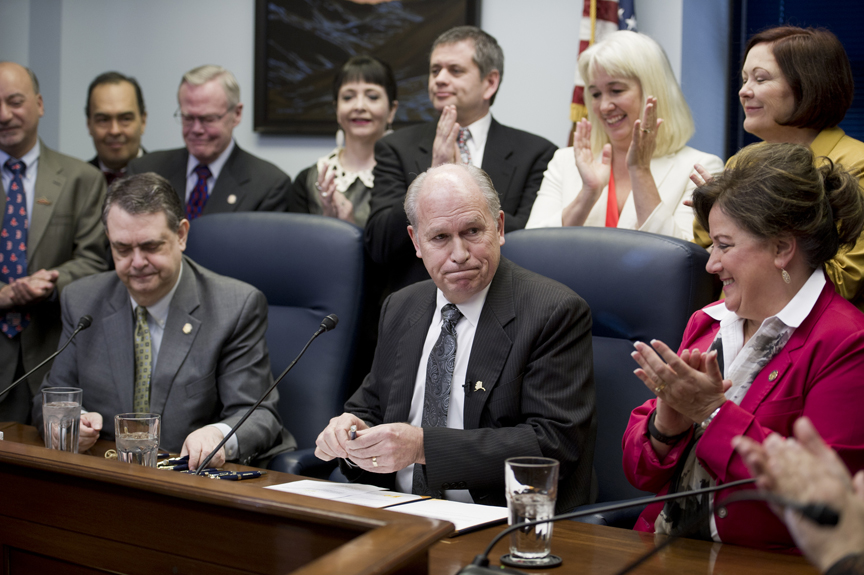Gov. Bill Walker reacts to the applause of legislators after signing Senate Bill 23 at the Capitol on Monday. The bill gives legal protection to those administering Naloxone, or Narcan, a drug that stops active opioid overdoses. Sen. Johnny Ellis, D-Anchorage, sitting left, and Rep. Lynn Gattis, R-Wasilla, sitting right, sponsored the bill in the Senate and House.