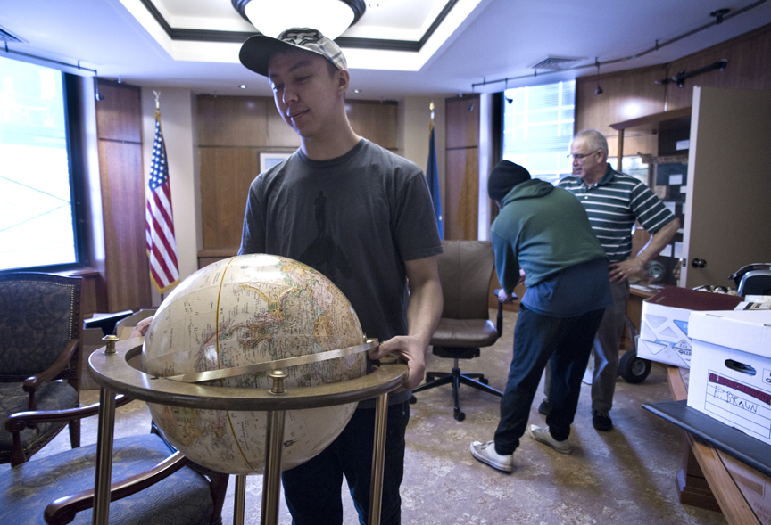 Jim Hoff with the Department of Administration, right, directs Erik Pedersen, left, and Josh Tagalon of World Wide Movers as they move furniture out of the Governor's Office at the Capitol on Thursday. The Governor's Office is now located in the Community Building on Third Street as construction at the Capitol continues.