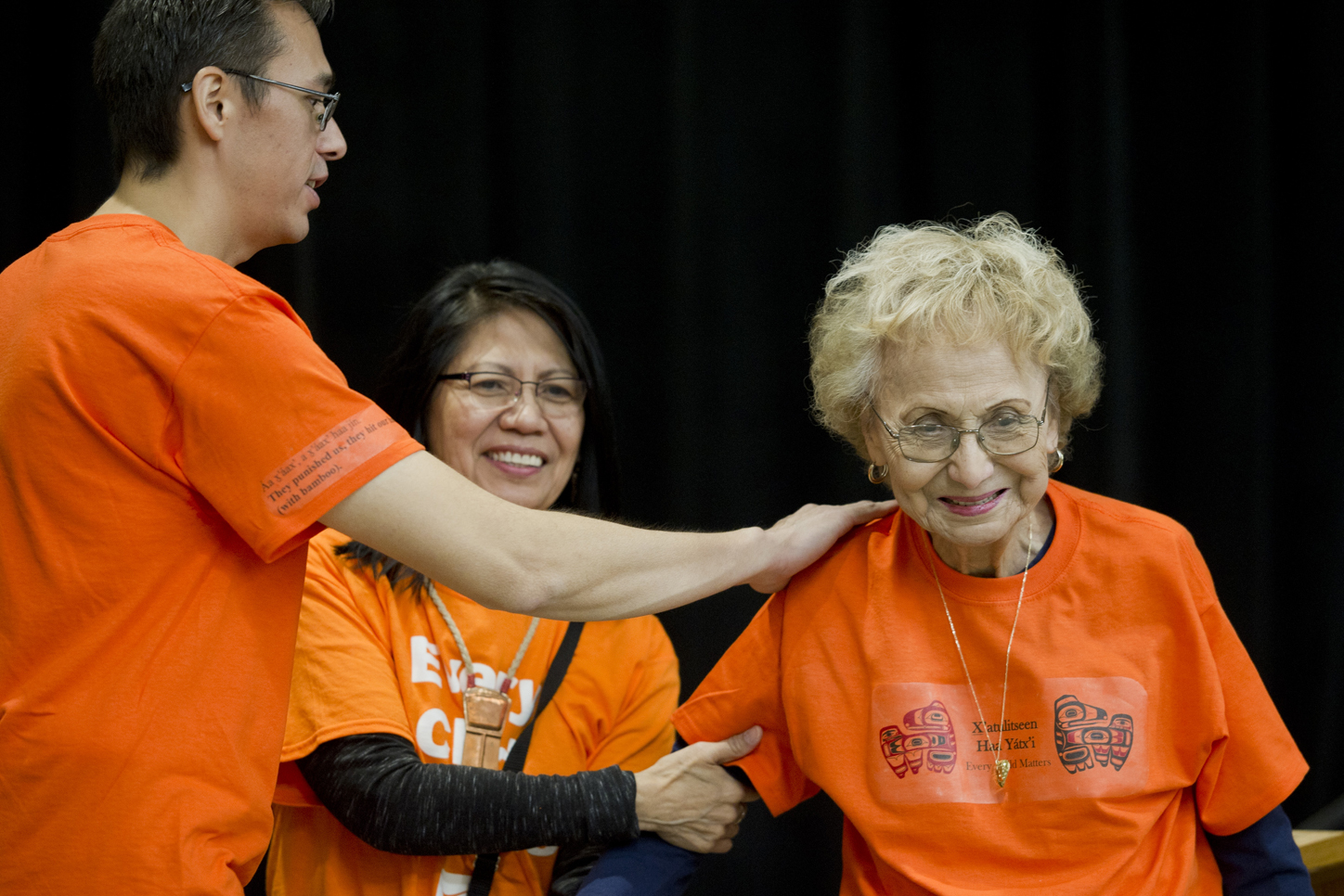 Teacher Hans Chester, left, and Barbara Cadiente-Nelson, center, thank elder Selina Everson for speaking to students, teachers and parents celebrating Orange Shirt Day in the Elizabeth Peratrovich Hall on Friday.