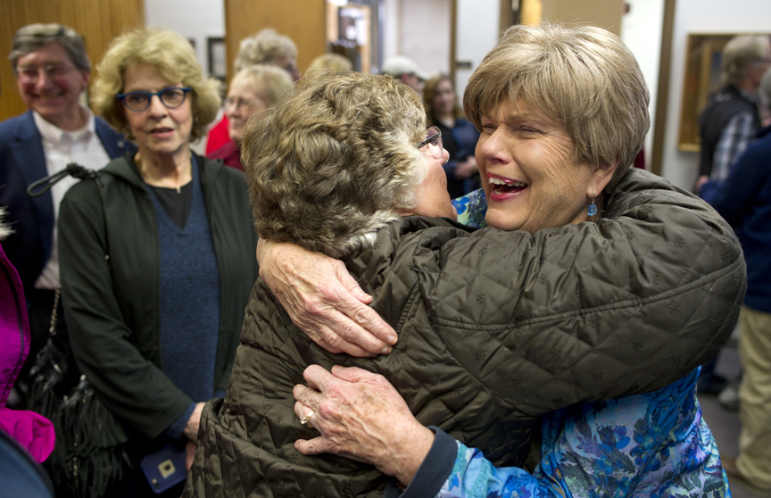 Mary Becker, right, is congratulated by Rosemary Hagevig in the Assembly chambers after retaining her Assembly seat during Tuesday's municipal election.