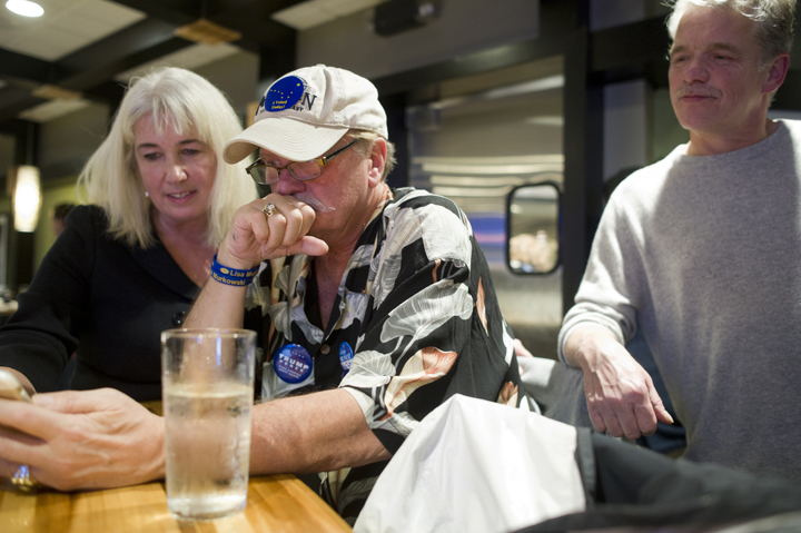 Rep. Cathy Muñoz and her husband, Juan, right,watch national and state elections results with Don Kubley, center, during a party at the Canton Asian Bistro on Tuesday.
