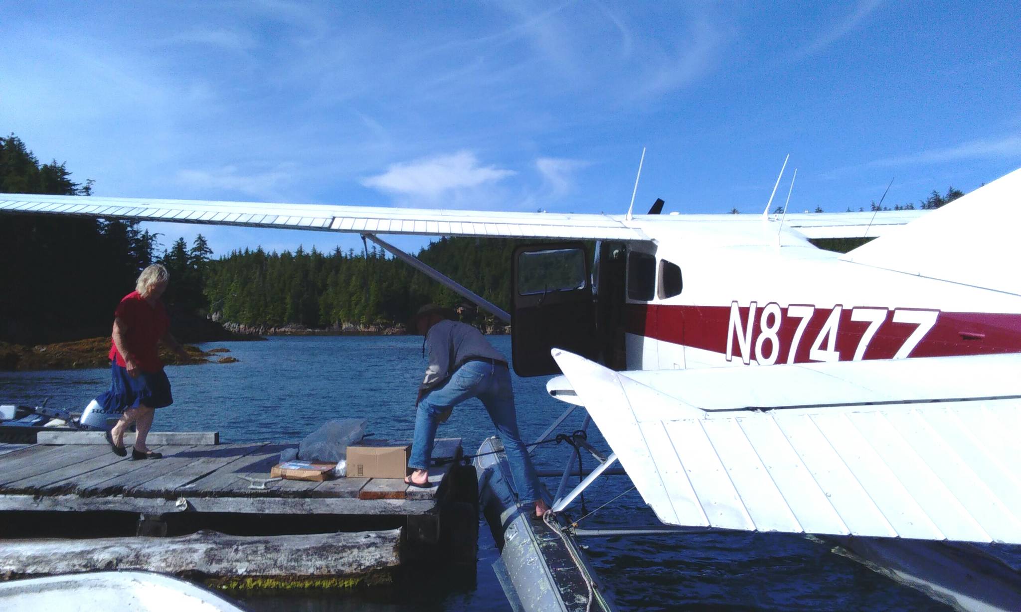 Post Mistress of Meyers Chuck, Cassie Peavey, greets the floatplane pilot and helps him unload this week’s mail. (Tara Neilson | For the Capital City Weekly)