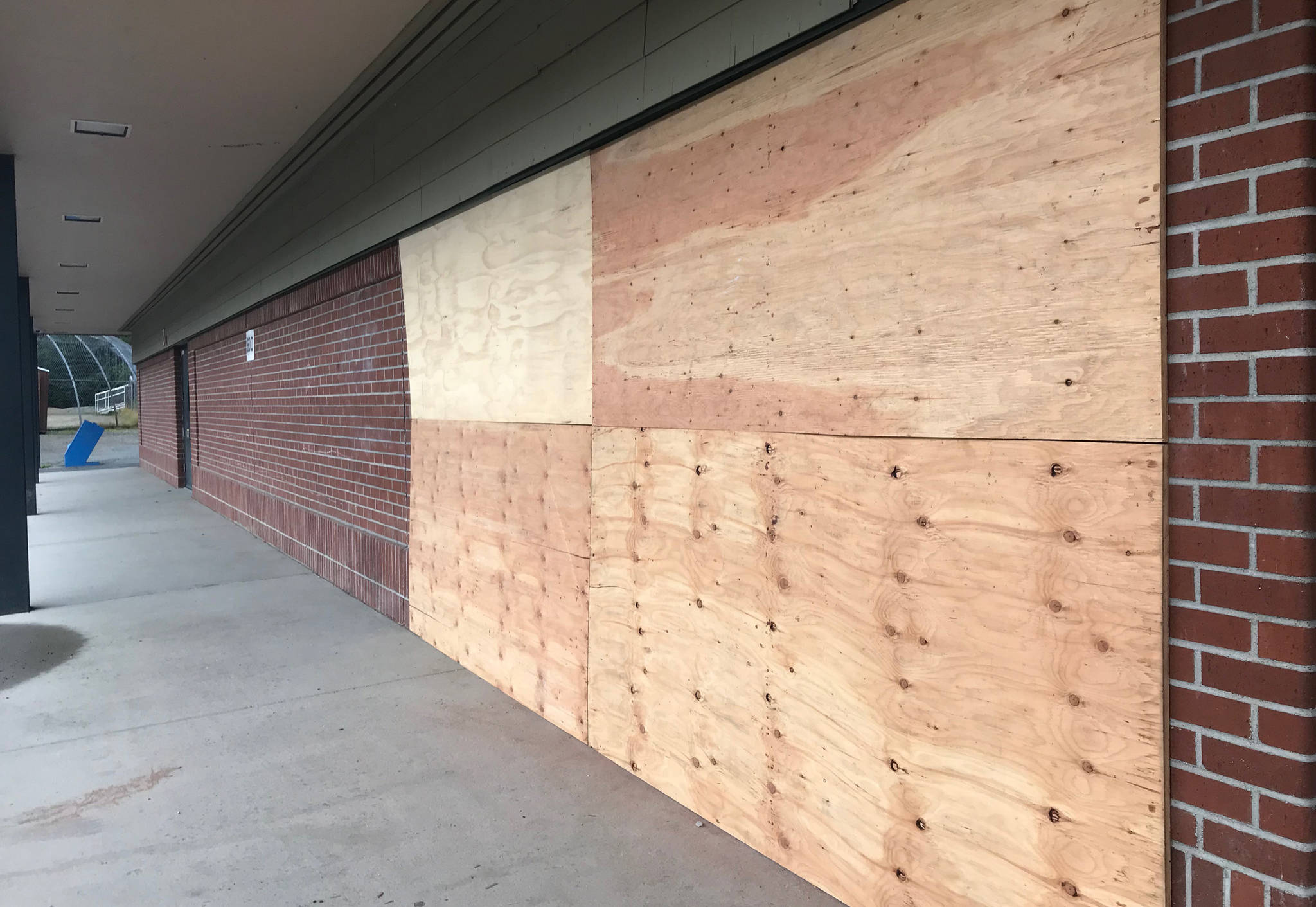 Wooden boards cover up damage made by a drunk driver at Dzantik’i Heeni Middle School on Tuesday, Aug. 7, 2018. The crash occurred July 31, police say. (Alex McCarthy | Juneau Empire)
