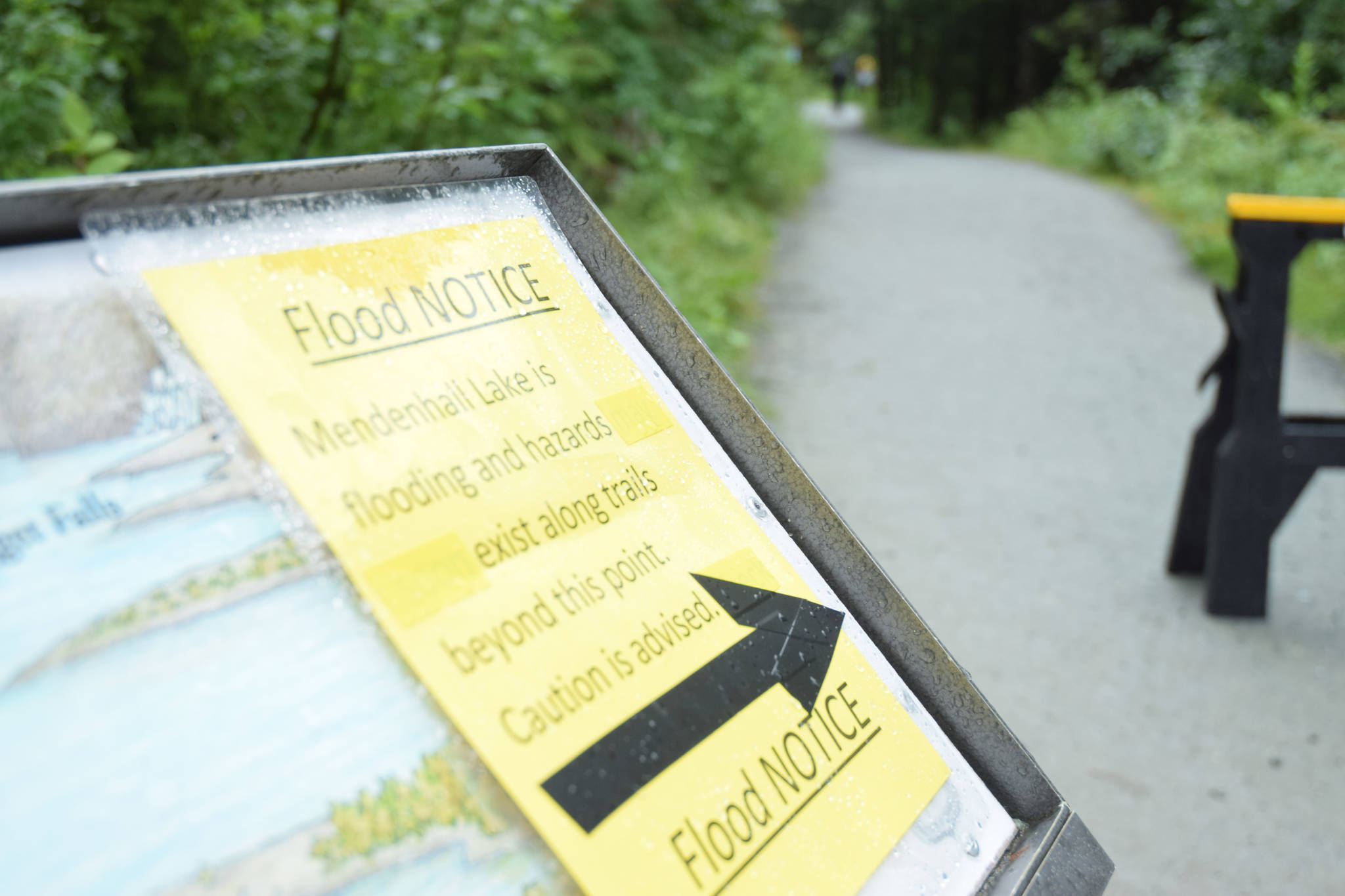 A sign at the start of Nugget Falls Trail, near the Mendenhall Glacier, warns visitors of flooding on the popular pathway. (Kevin Gullufsen | Juneau Empire)