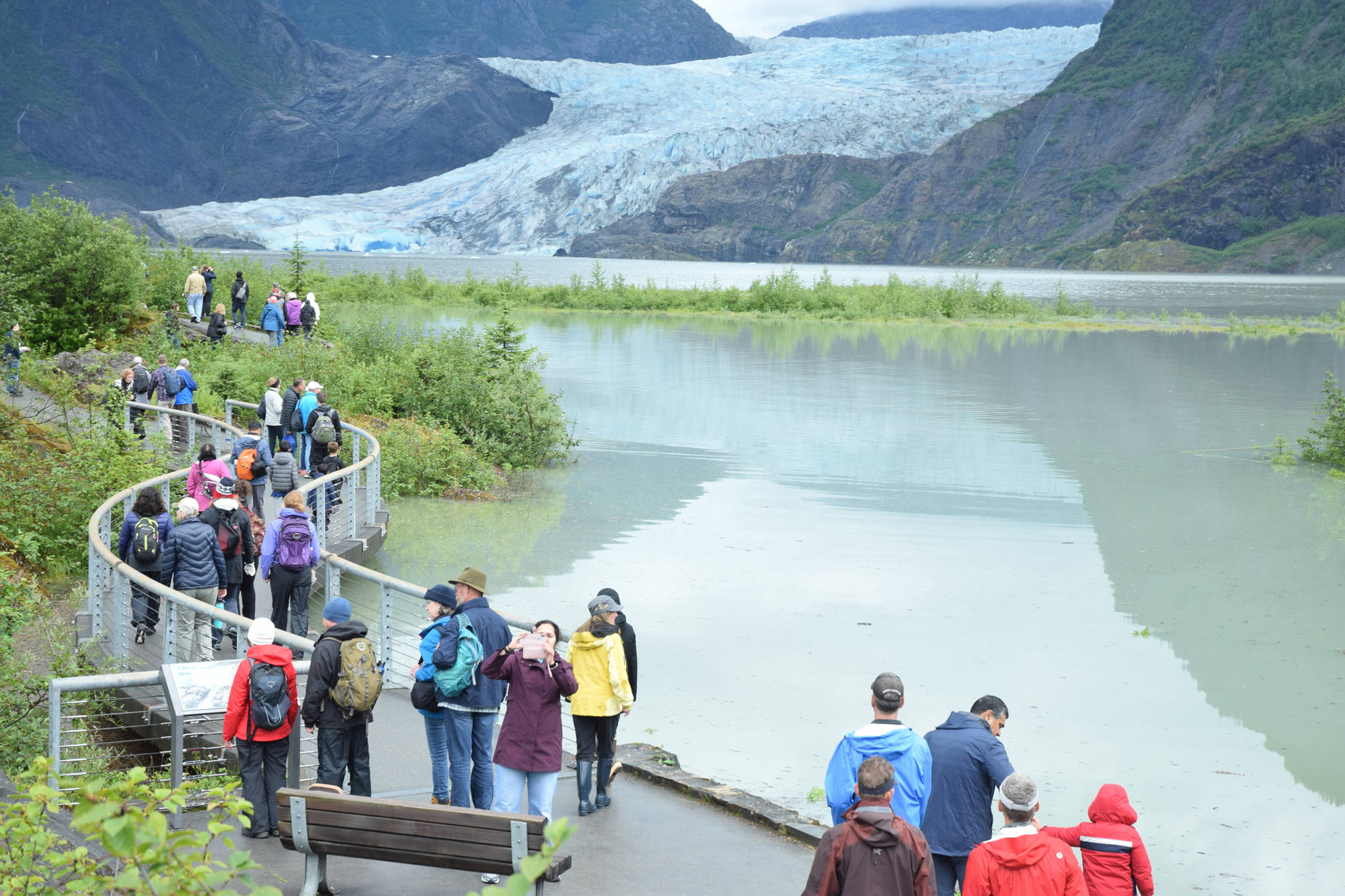 Visitors walk to Photo Point above a flooded Mendenhall Lake on Wednesday, Aug. 8, 2018. (Kevin Gullufsen | Juneau Empire)
