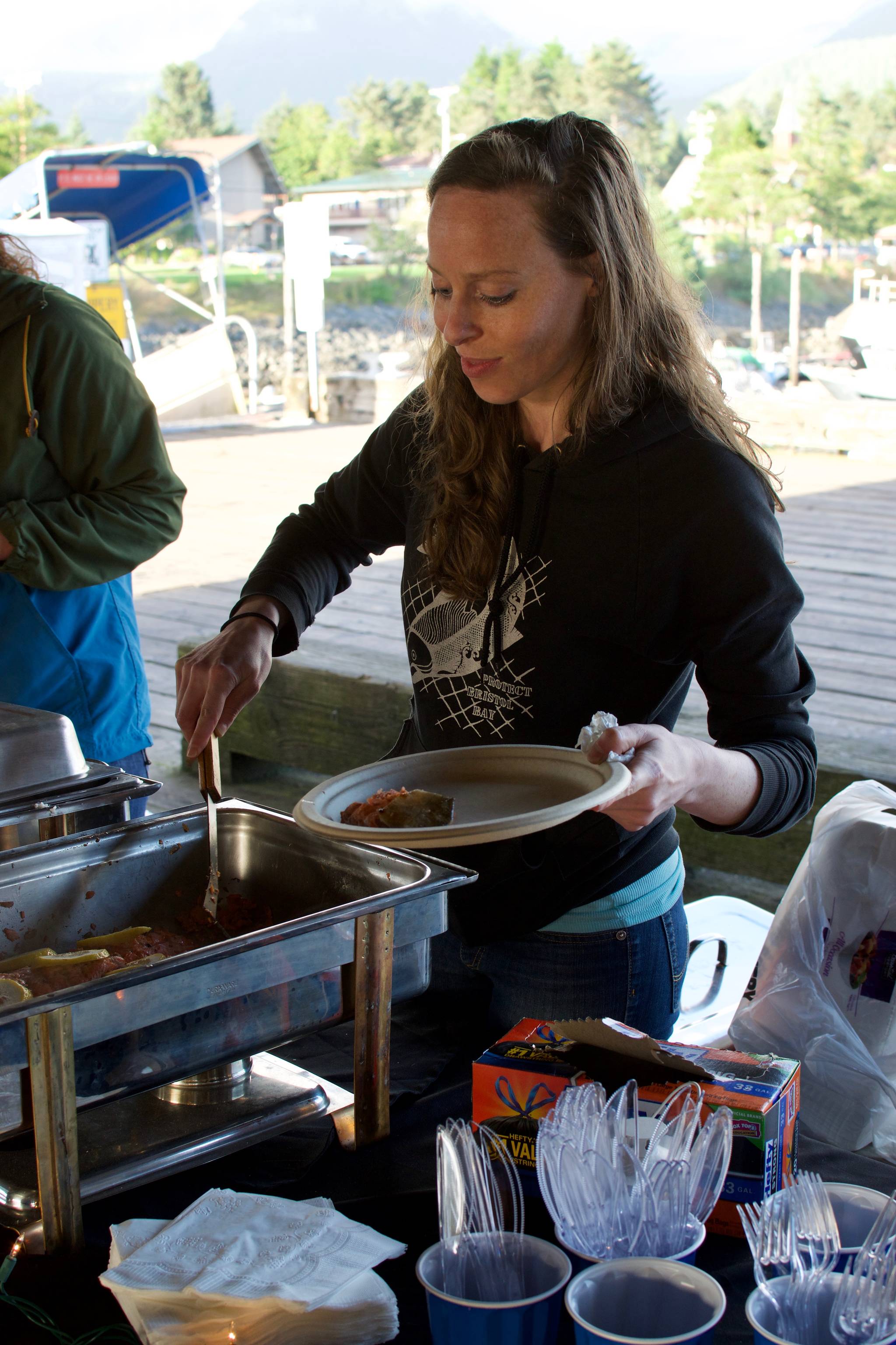 Aurora Lang serves freshly grilled salmon to an attendee at the Sitka Seafood Festival.