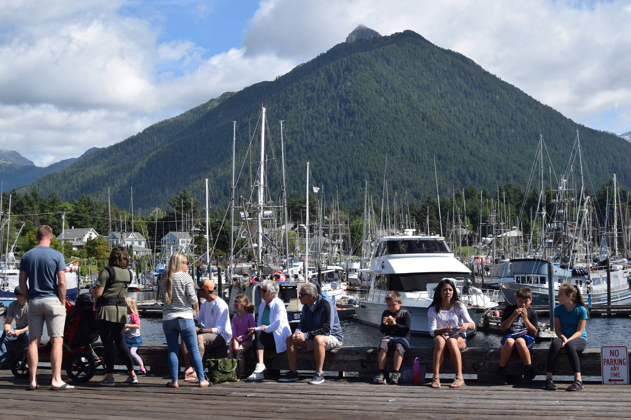 Seafood festival attendees enjoy a meal by Crescent Harbor in Sitka. (Maia Mares | For the Capital City Weekly)