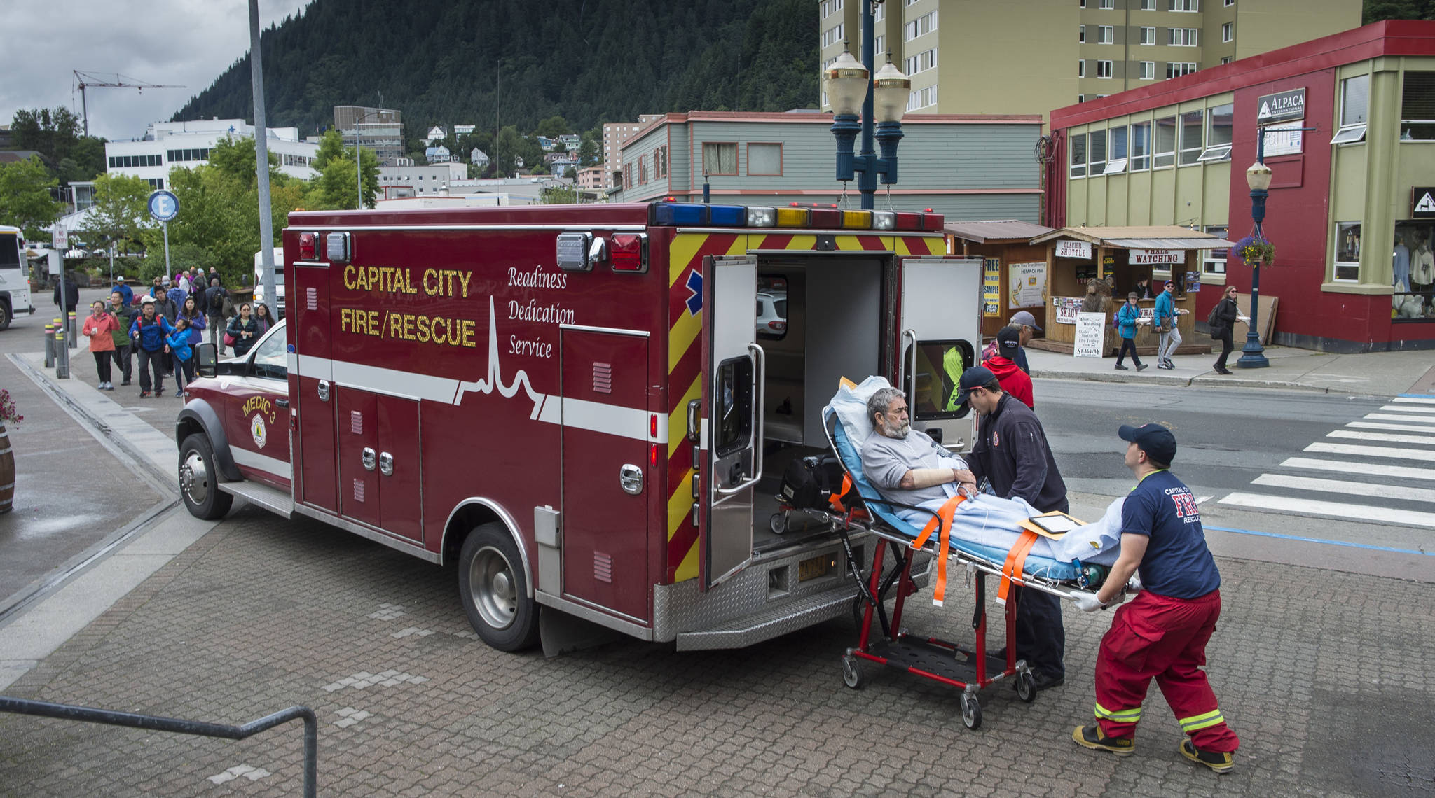 A Capital City Fire/Rescue crew transports a cruise ship passenger off the Radiences of the Seas downtown on Tuesday, August 14, 2018. (Michael Penn | Juneau Empire)