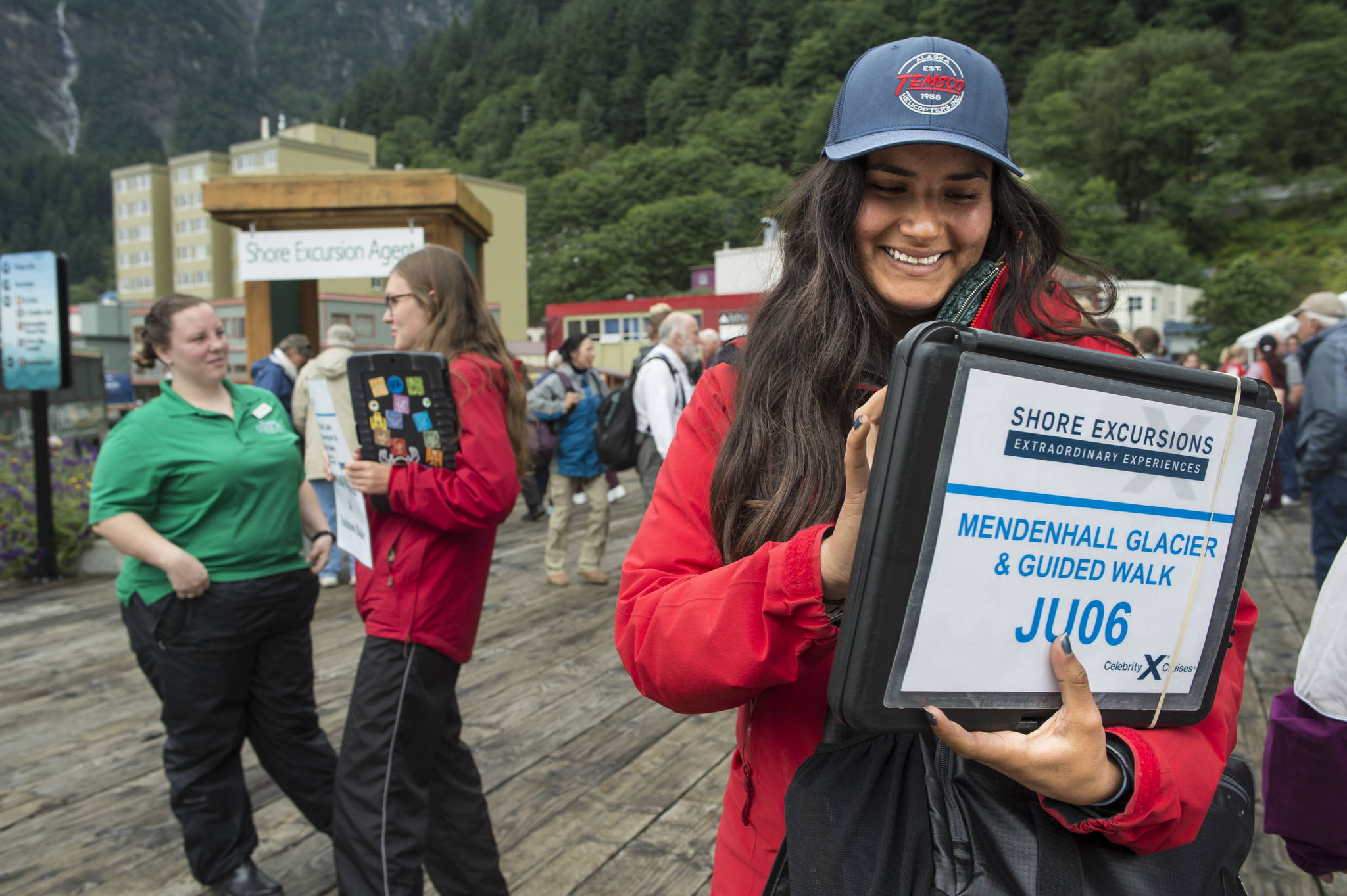 Maria Covarrubian, right, Maddie Simbirdi, center, and Kourtney Howard wait to direct cruise ship passengers to their excursions downtown on Tuesday, August 14, 2018. (Michael Penn | Juneau Empire)
