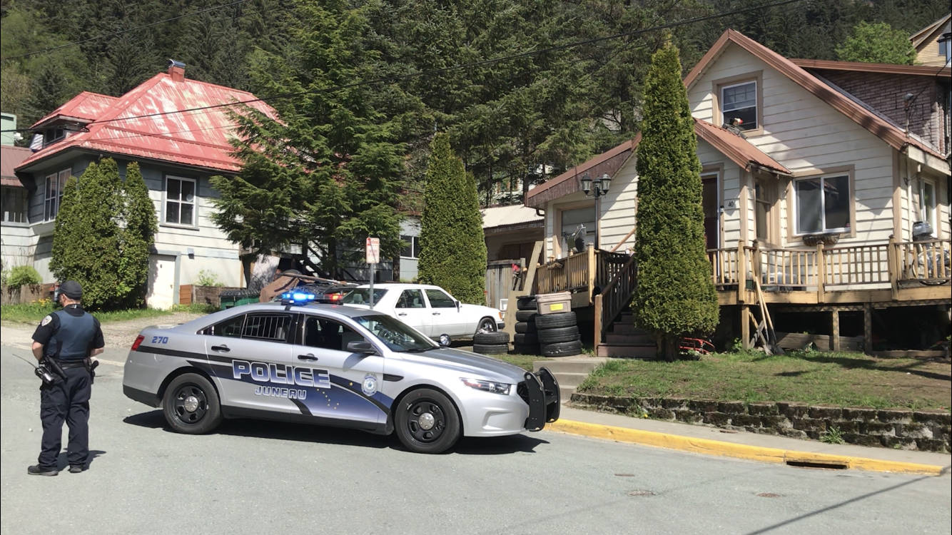 A Juneau Police Department car sits in front of 401 Harris Street as police officers search it Wednesday, May 16, 2018. (Alex McCarthy | Juneau Empire File)
