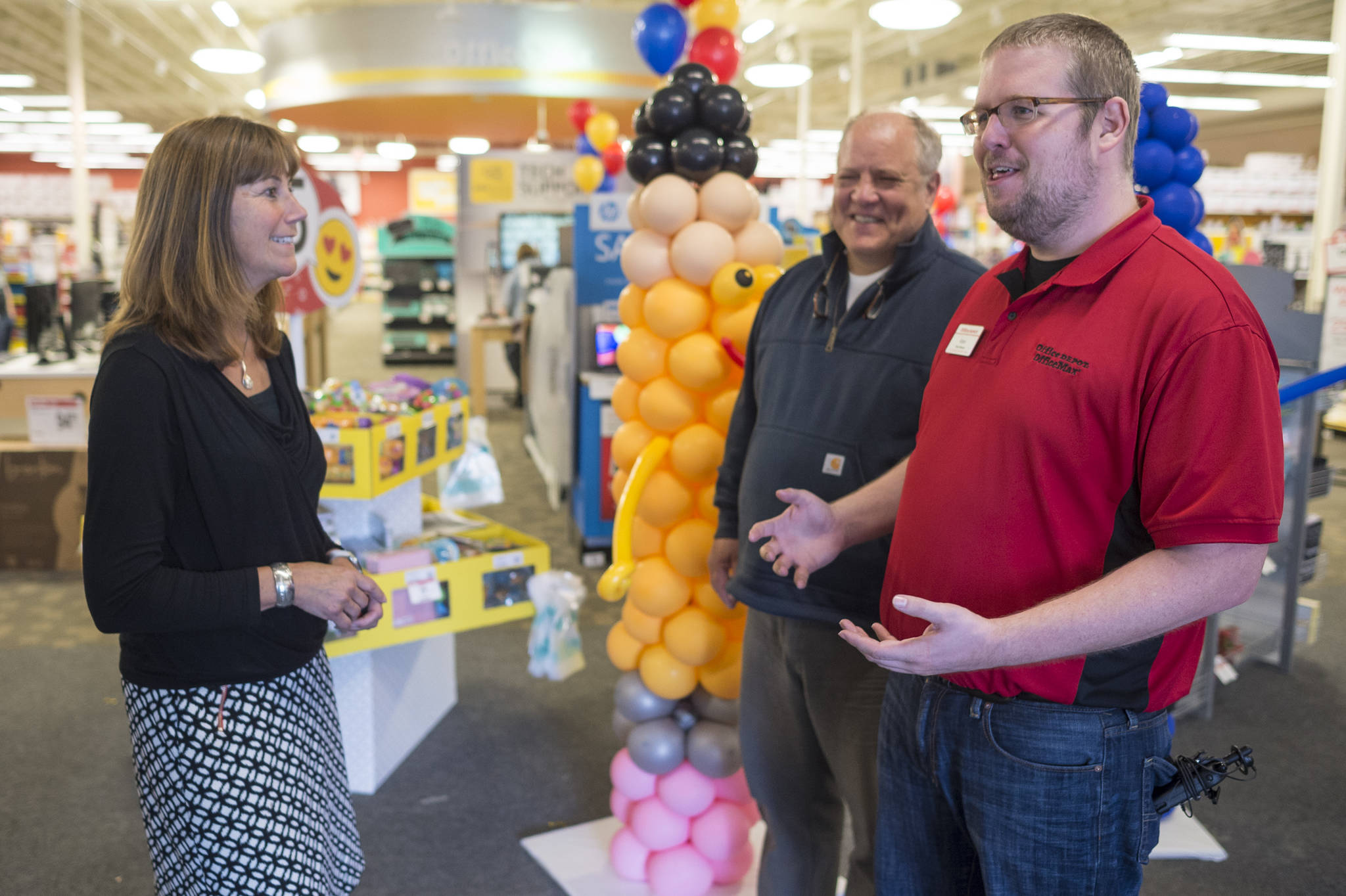 Dr. Bridget Weiss, Interim Juneau School District Superintendent, left, and Harborview Elementary School special education teacher Steve Byers, center, speak with Office Max store manager Adam Dordea on Thursday, August 16, 2018, during a store fundraising event for elemenary schools. Office Max pledged to donate up to $10,000. (Michael Penn | Juneau Empire)