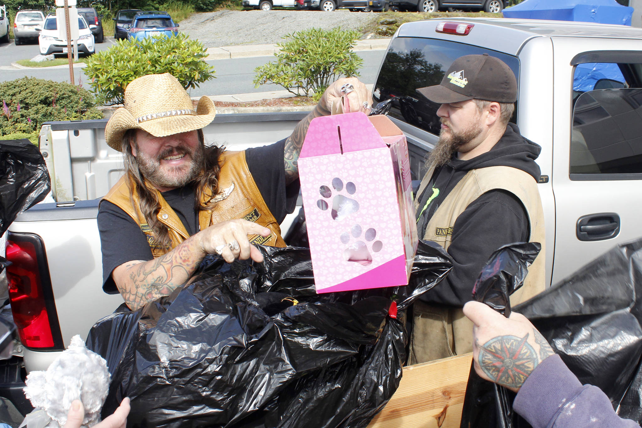 Southeast Alaska Panhandlers Motorcycle Club Sargent-at-Arms Steve “Shiner” Buckhouse points at a Puppy Surprise toy as the club donated about 500 toys to the Bartlett Regional Hospital as part of its 24th annual Toy Run on Friday, Aug. 17, 2018. (Alex McCarthy | Juneau Empire)
