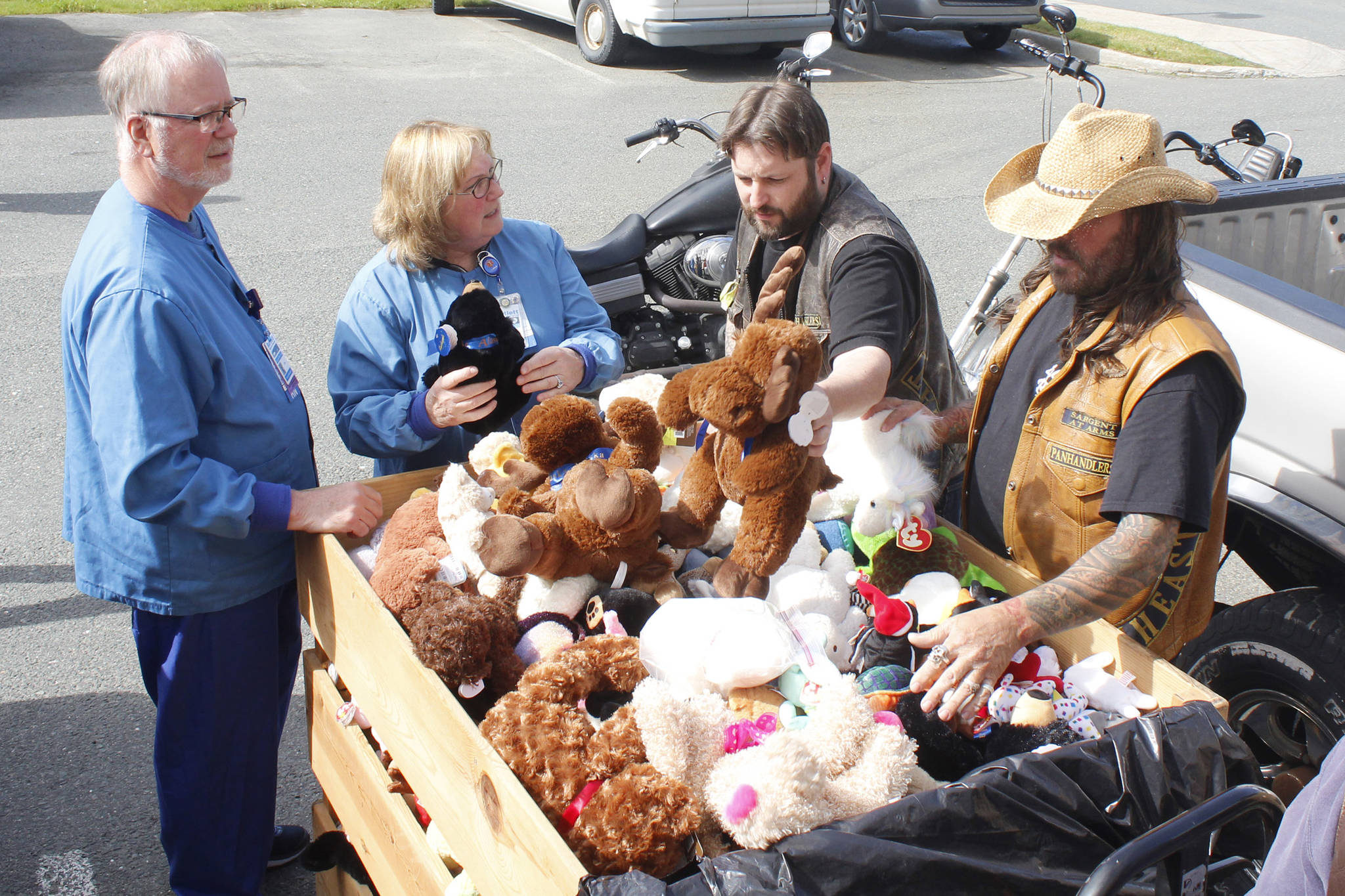 Operating Room Nurse Managers James Jurrens and Sherry O’Connor admire the haul of toys as Southeast Alaska Panhandlers Motorcycle Club Secretary Justin Papenbrock (third from left) and Sargent-at-Arms Steve “Shiner” Buckhouse (far right) put toys in a crate at Bartlett Regional Hospital on Friday, Aug. 17, 2018. The club donated about 500 toys to the hospital as part of its 24th annual Toy Run. (Alex McCarthy | Juneau Empire)
