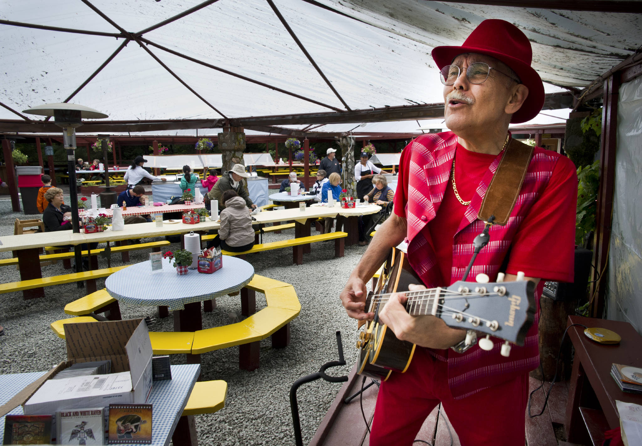 In this July 2015 photo, musician Archie Cavanaugh plays his guitar during lunch hour Friday at the Gold Creek Salmon Bake near Twin Lakes. (Michael Penn | Juneau Empire)