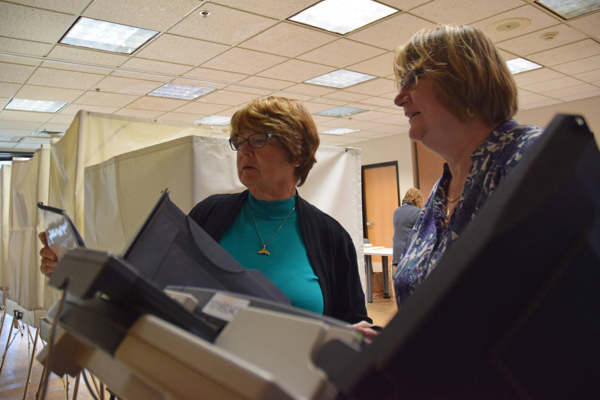 Election volunteers at the Douglas Public Library set up the touch-screen voting machine before the polls open Tuesday morning, Aug. 21, 2018. (James Brooks | Juneau Empire)
