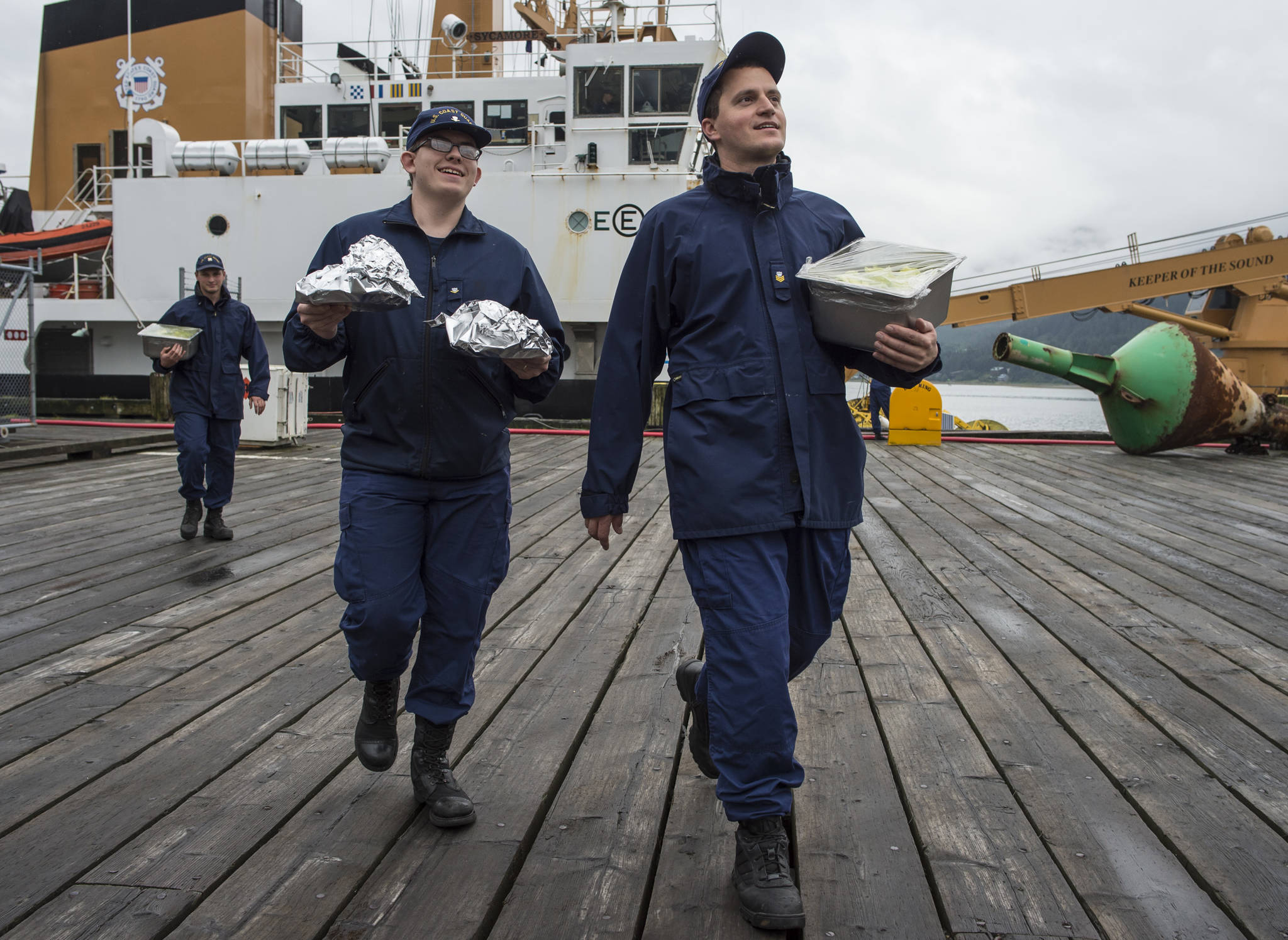 Chefs Berkeley Scott and Matthew Koran, right, from the buoy tender Hickory, walk their burgers to waiting contest judges on Thursday, Aug. 23, 2018. (Michael Penn | Juneau Empire)