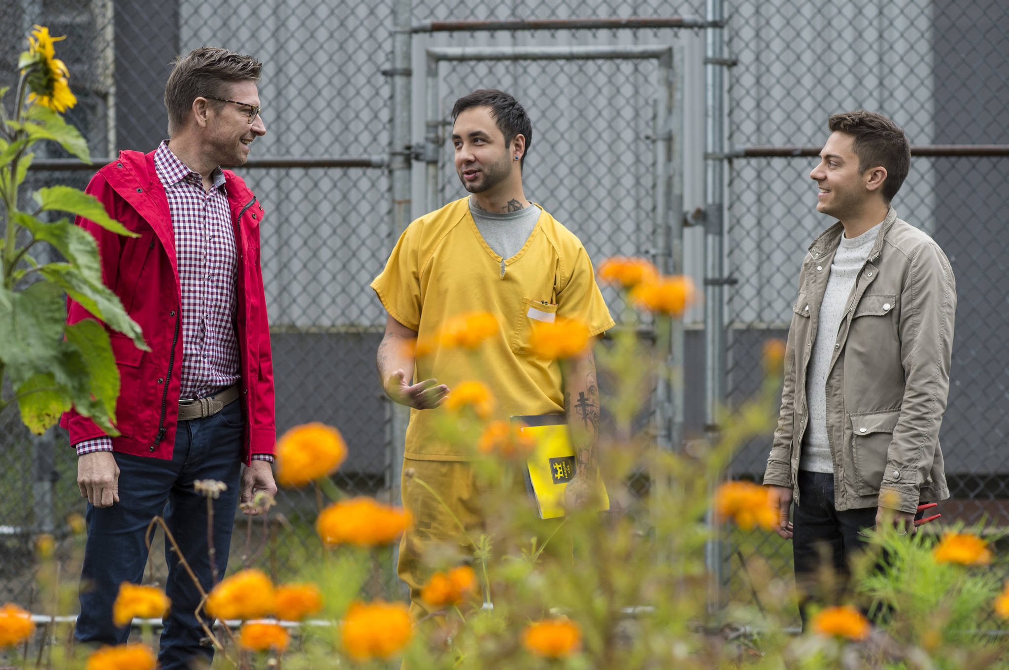 Jeremy Bauer, left, and Jason Clifton, right, of Frenchie’s Floral Studio, talk with inmate Patrick Sweeney about a flower-growing collaboration at Lemon Creek Correctional Center on Friday, Aug. 24, 2018. (Michael Penn | Juneau Empire)