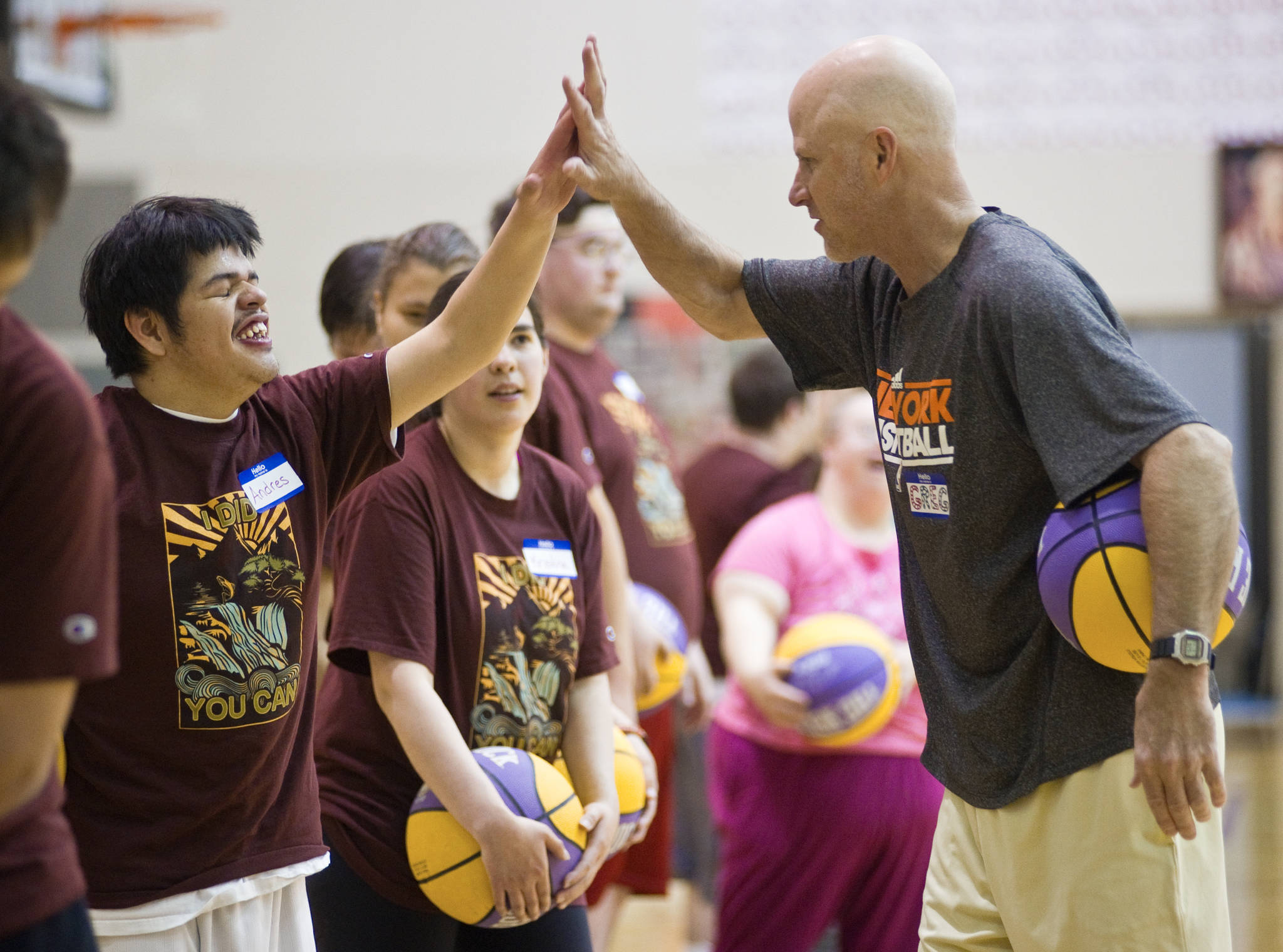 Greg Brittenham gives Andres Jones a high five during a three-day basketball camp for physically and mentally challenged athletes at Juneau-Douglas High School in June of 2014. (Michael Penn | Juneau Empire File)