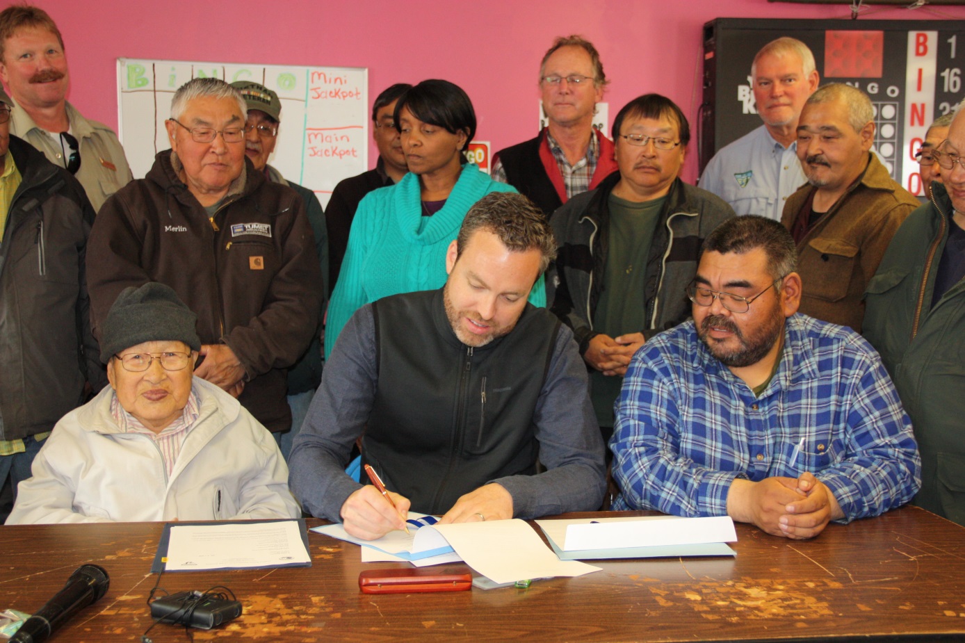 Bureau of Land Management Director Neil Kornze signs a patent transferring 1 million acres of land to Kukulget Inc. of Savoonga and the Sivuqaq Inc. of Gambell during a ceremony on St. Lawrence Island, Alaska, July 27, 2016.