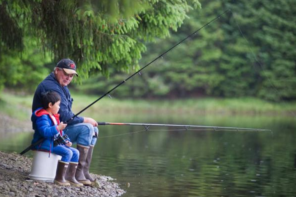 In this file photo from June 2014, Kent Eriksen fishes for king salmon with his grandson, Diego, 5, at the Fish Creek Pond.