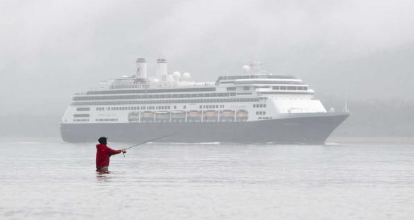 In this file Aug. 24 photo, a fisherman casts a lure at the mouth of Sheep Creek as Holland America’s Amsterdam arrives in Juneau.