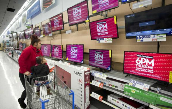 In this file photo from November 2015, Ceivarenn Isaako walks with her daughter, Mareanna, 3, through the electronics department at Walmart ahead of the store's Black Friday sale.