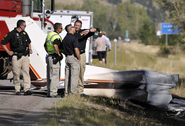 Missoula County sheriff's deputies look at the wreckage of a Cessna 182 that crashed on the shoulder of Interstate 90 near Rock Creekont., on Sunday, Aug. 28, 2016. The crash killed 52-year-old Darrell Ward of Deer Lodge, a star of the History channel series "Ice Road Truckers" and pilot Mark Melotz, 56, of Arlee. Ward was returning to Montana to film a pilot episode of a documentary-type series about the recovery of plane wrecks.