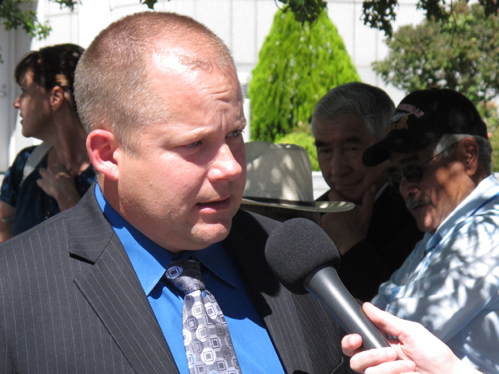 Members of the Pyramid Lake Paiute Tribe and Walker River Paiute Tribe talk in the background outside the federal courthouse as their lawyer, Rendal Miller of Winnemucca, Nev., discusses the lawsuit they filed under the Voting Rights Act of 1965, Wednesday, Sept. 7, 2016 in Reno, Nev. The suit seeks a temporary injunction ordering the state and Washoe and Mineral counties to establish satellite polling places on reservations where they say Native Americans are being denied an equal opportunity to vote in the November elections.