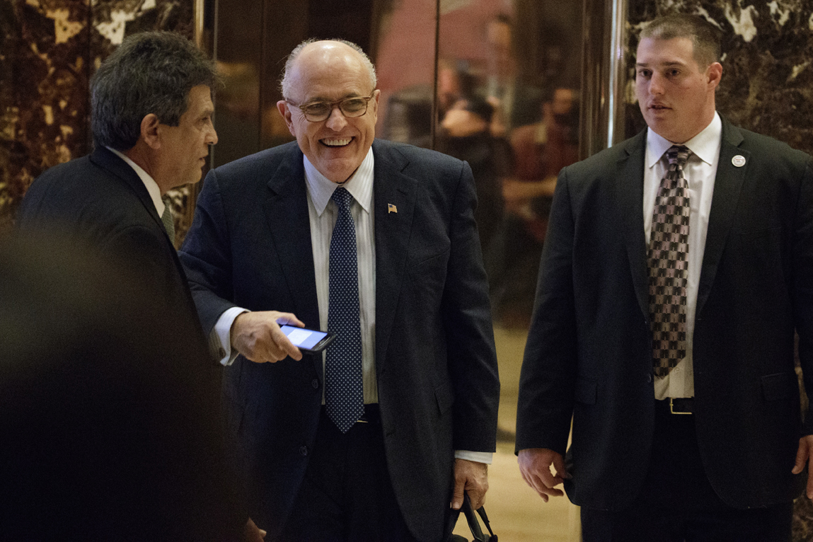 Former New York Mayor Rudy Giuliani, center, smiles as he leaves Trump Tower, Friday, Nov. 11 in New York.