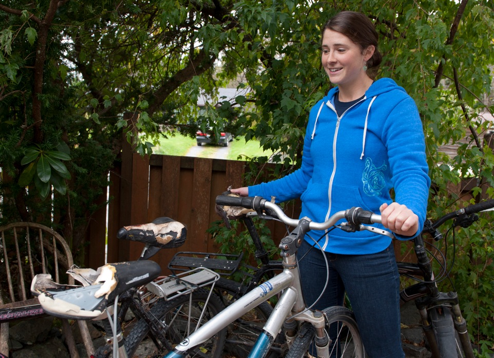 Andrea Pitz holds up some of the bicycles that a bear chewed up over the weekend. A bear apparently tore the seats and punctured all the tires on the four bicycles that were parked at the Medvejie trail.