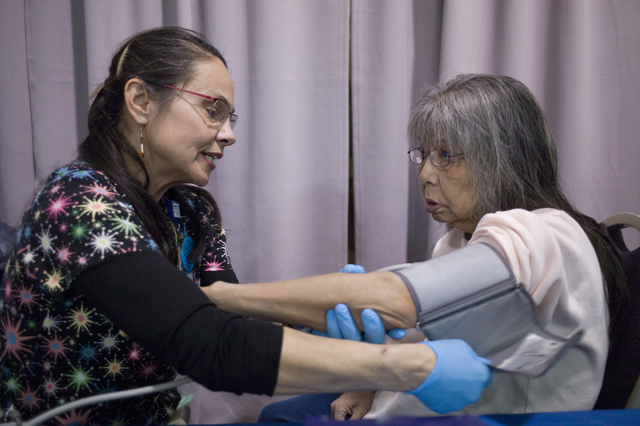 Mynita Gonzales, right, has her blood pressure, blood sugar and cholesterol checked by Laura Stats, of Bartlett Regional Hospital, during the Juneau Coalition on Housing & Homelessness’ Project Homeless Connect in the Juneau Arts & Culture Center on Wednesday, Jan. 25, 2017. (Michael Penn | Juneau Empire)