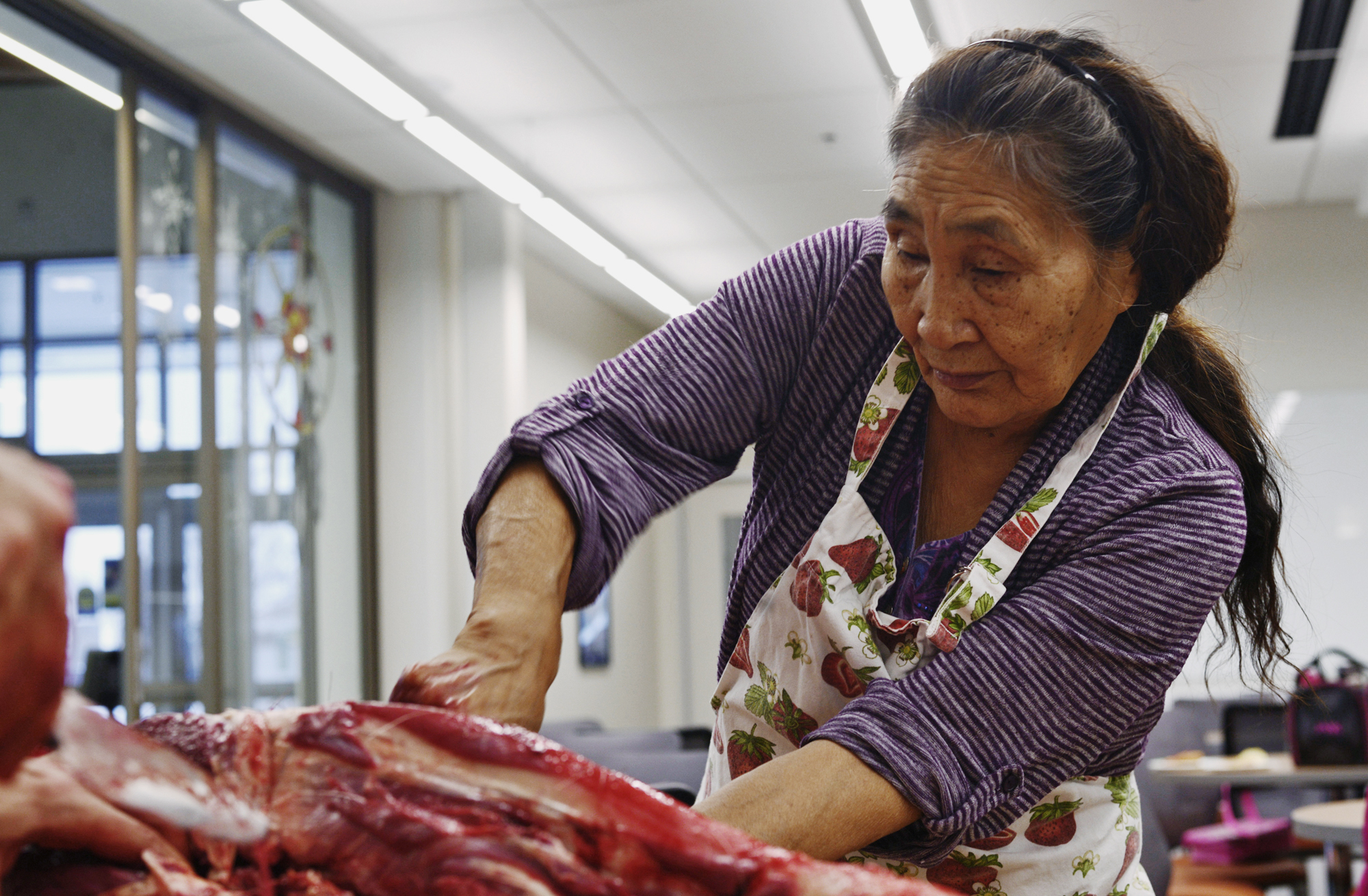 In this Jan. 27 photo, Dena’ina elder Helen Dick cuts meat from a moose head in the demonstration kitchen of the Dena’ina Wellness Center in Kenai, Alaska. Dick, who also helps teach a Dena’ina language class at Kenai Peninsula College, came to the Wellness Center to demonstrate the techniques of butchering and preparing moose head that she learned in her childhood. (Ben Boettger | Peninsula Clarion)