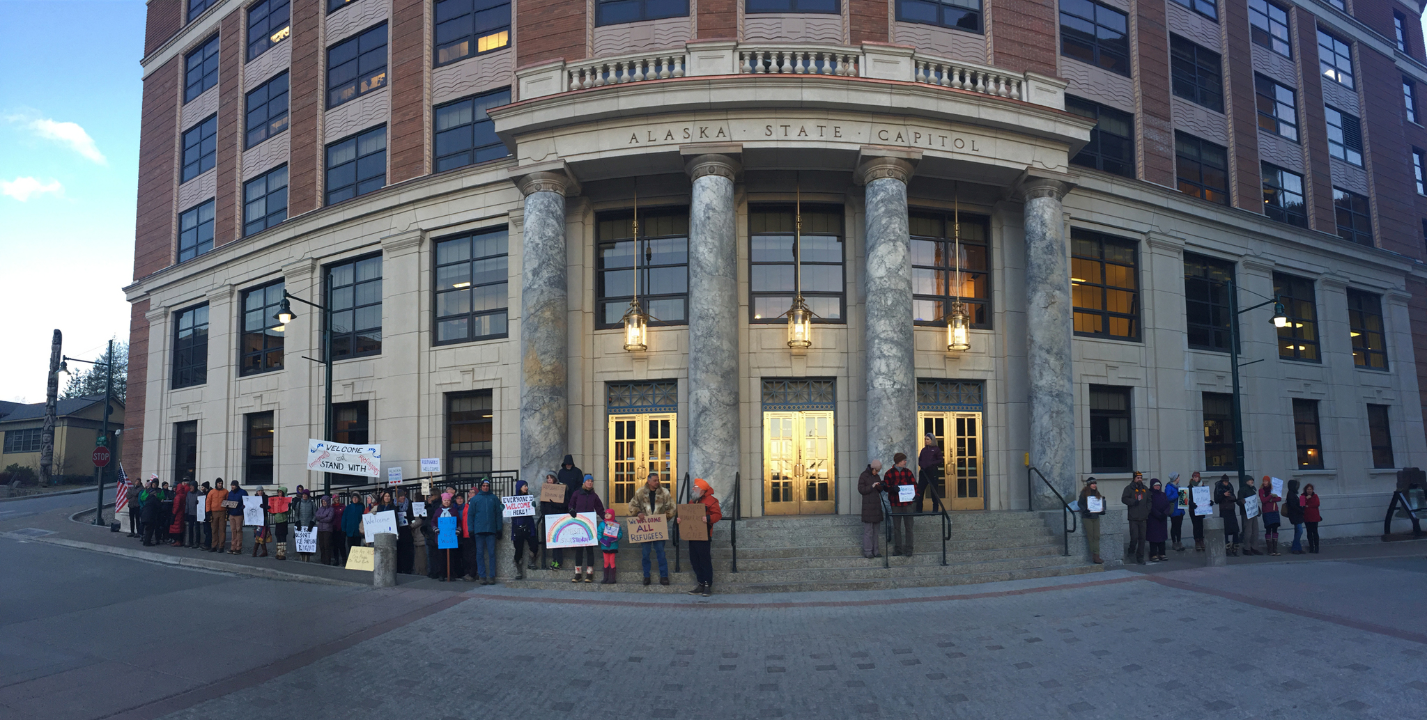 A panorama of the front of the Alaska Capitol shortly after 8 a.m. Monday shows several dozen people gathered to show support for refugees and immigrants. The first gathering, last week, attracted just fewer than 100 people. In an hour and a half, organizers collected 166 signatures asking Gov. Bill Walker to speak out against President Donald Trump’s executive order on immigration and refugees. (Mary Catharine Martin | Juneau Empire)