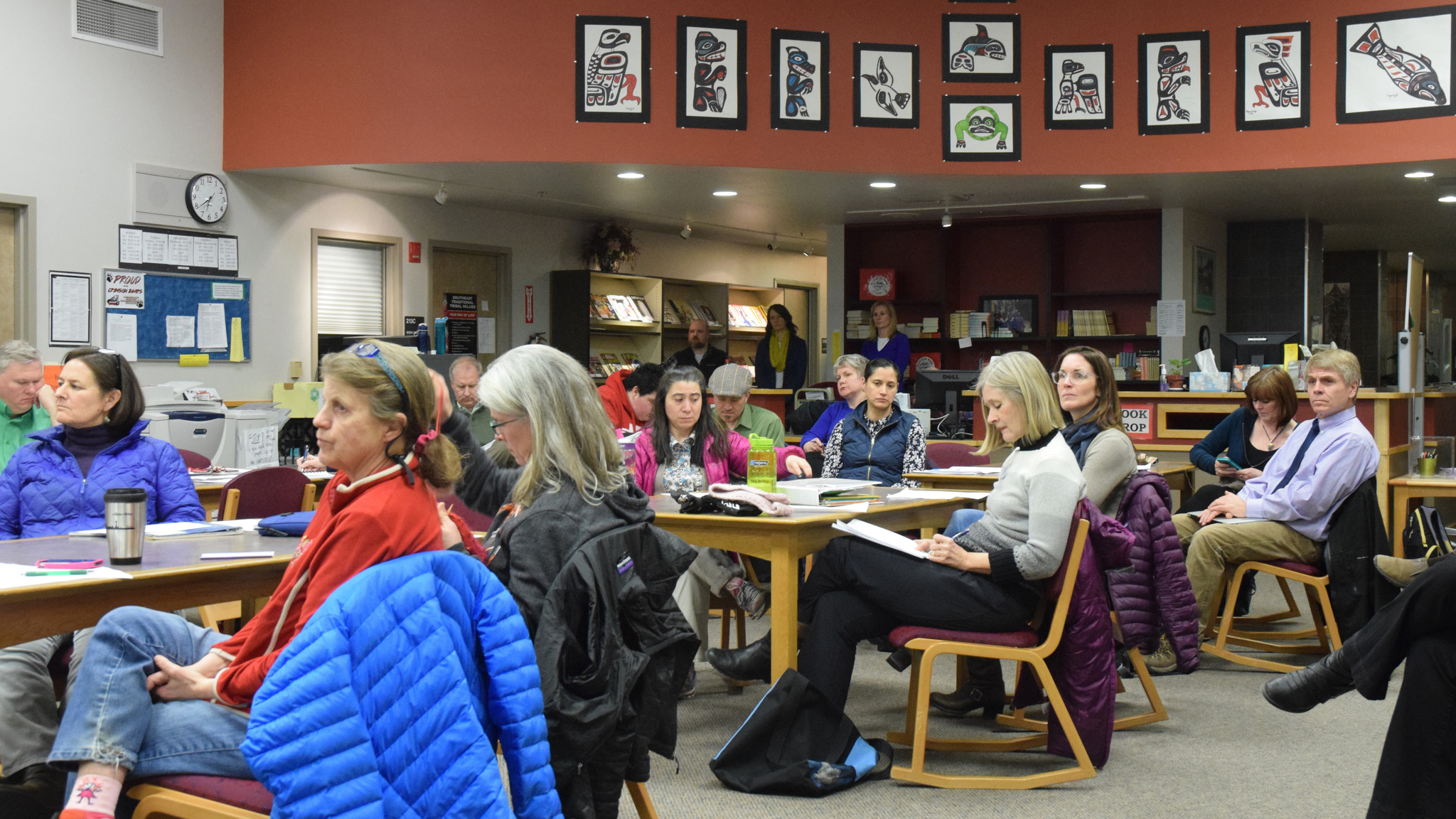 Members of the public listen to public testimony on the Juneau School District’s 2018 budget Tuesday at Juneau-Douglas High School library.