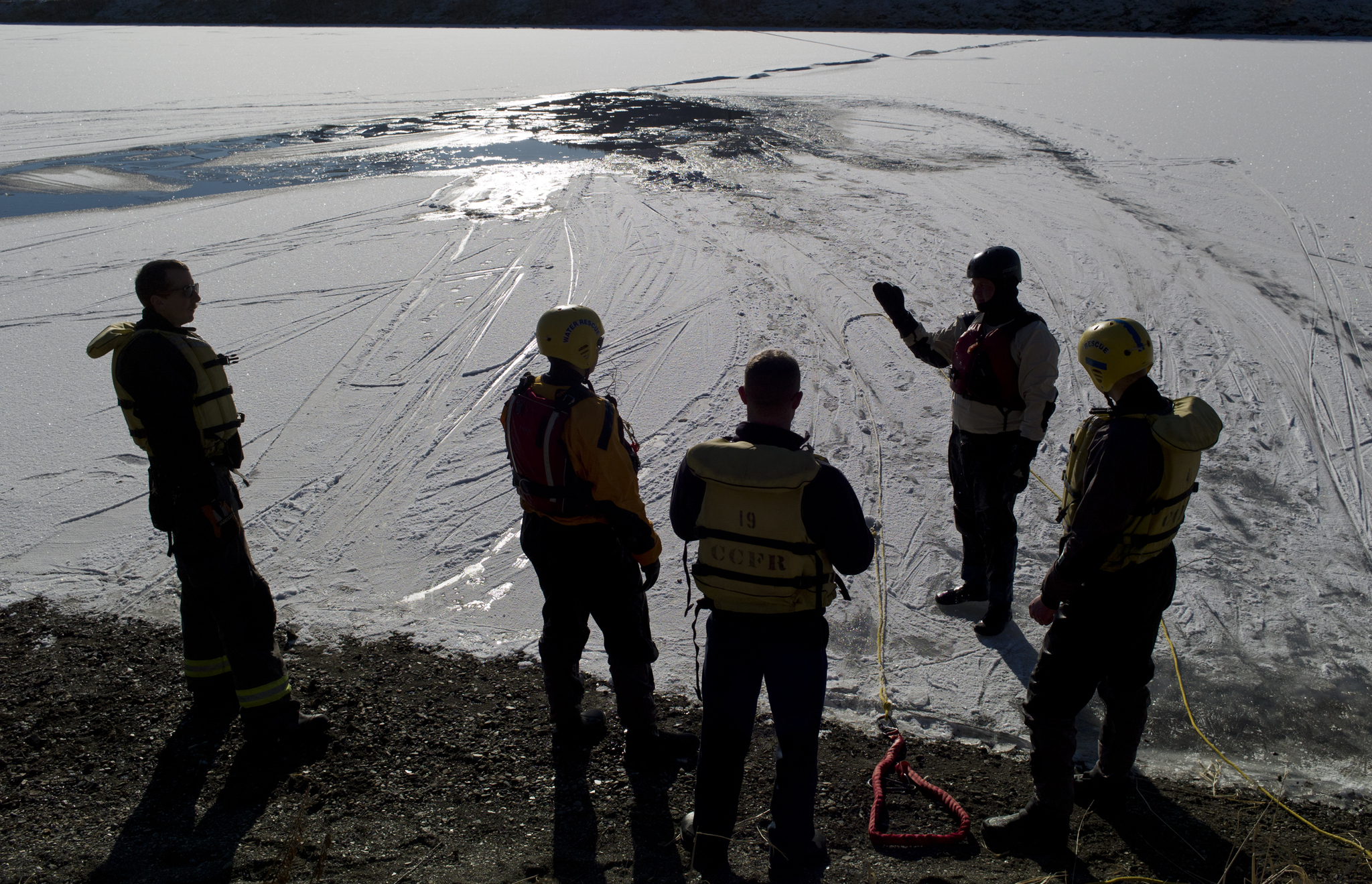 Capital City Fire/Rescue’s Noah Jenkins, left, Marcus Kinman, Andrew Bishop, Brady Fink and Chad Gustafson practice ice rescue training at Twin Lakes on Thursday. (Michael Penn | Juneau Empire)