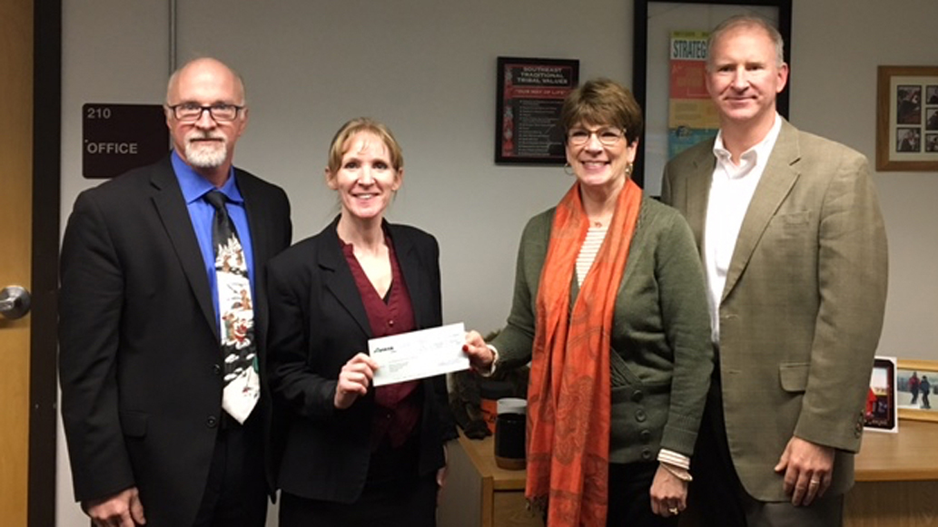 Juneau School District Superintendent Mark Miller, left, and Food Service Supervisor Adrianne Schwartz accept a check from Avista Communications manager Jessie Wuerst with Board of Education President Brian Holst. (Courtesy photo)