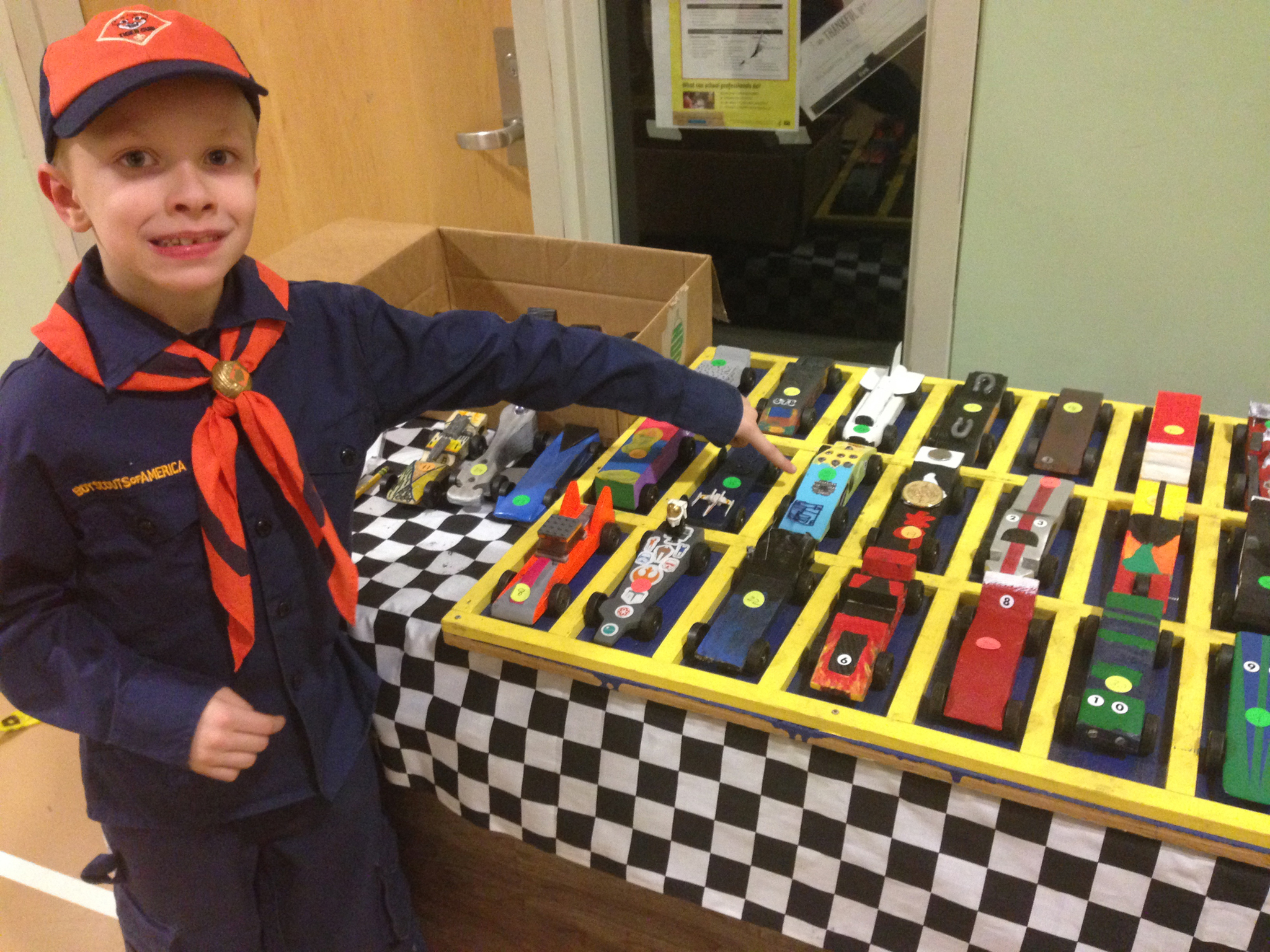 Tiger Cub Brevin points out his car in a display of some of the cars built and raced in the Pinewood Derby. (Courtesy photo)