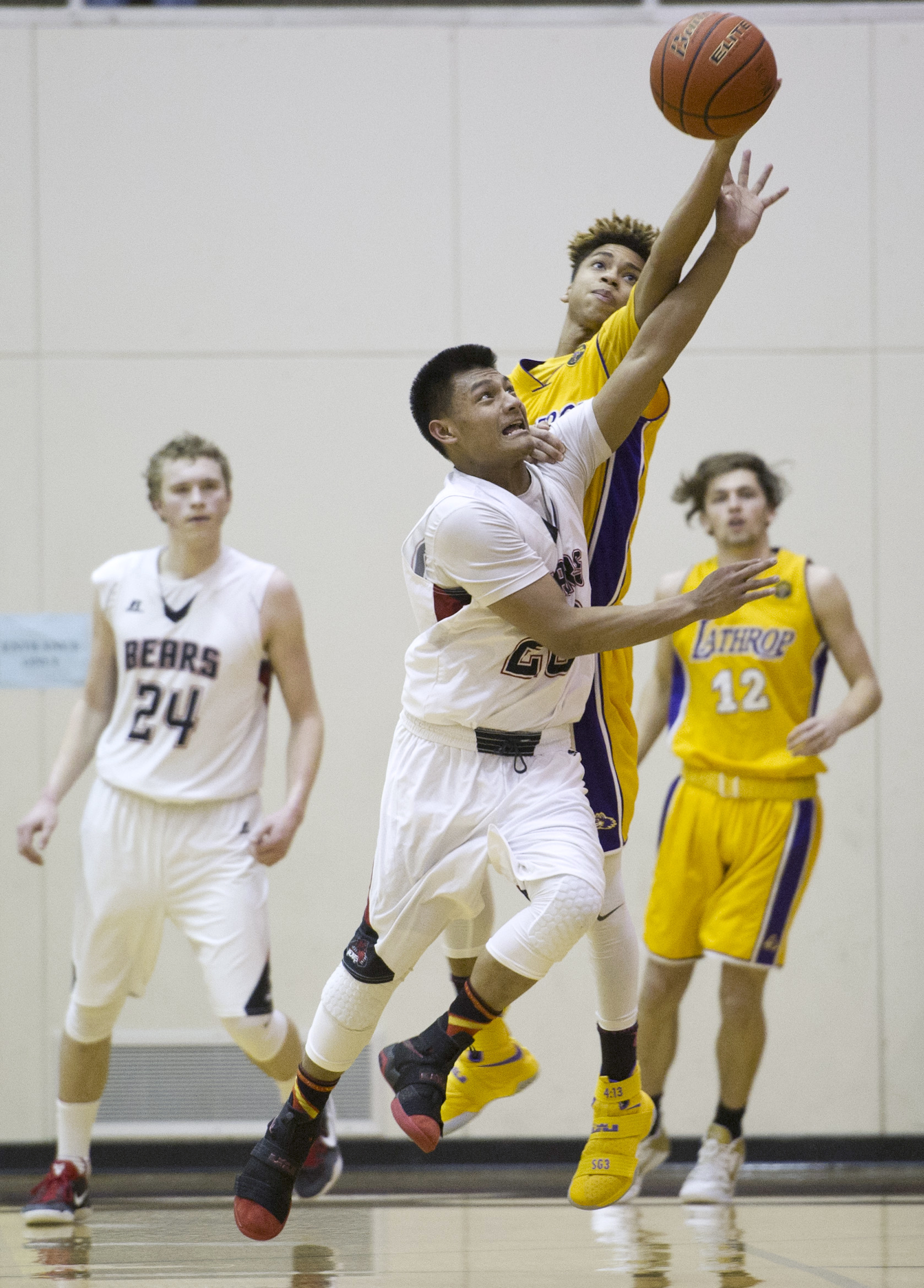 Juneau-Douglas’ Ulyx Bohulano compete against Lathrop’s Jeremiah Handy for the ball at JDHS on Friday, Feb. 10, 2017. JDHS won 50-43. (Michael Penn | Juneau Empire)
