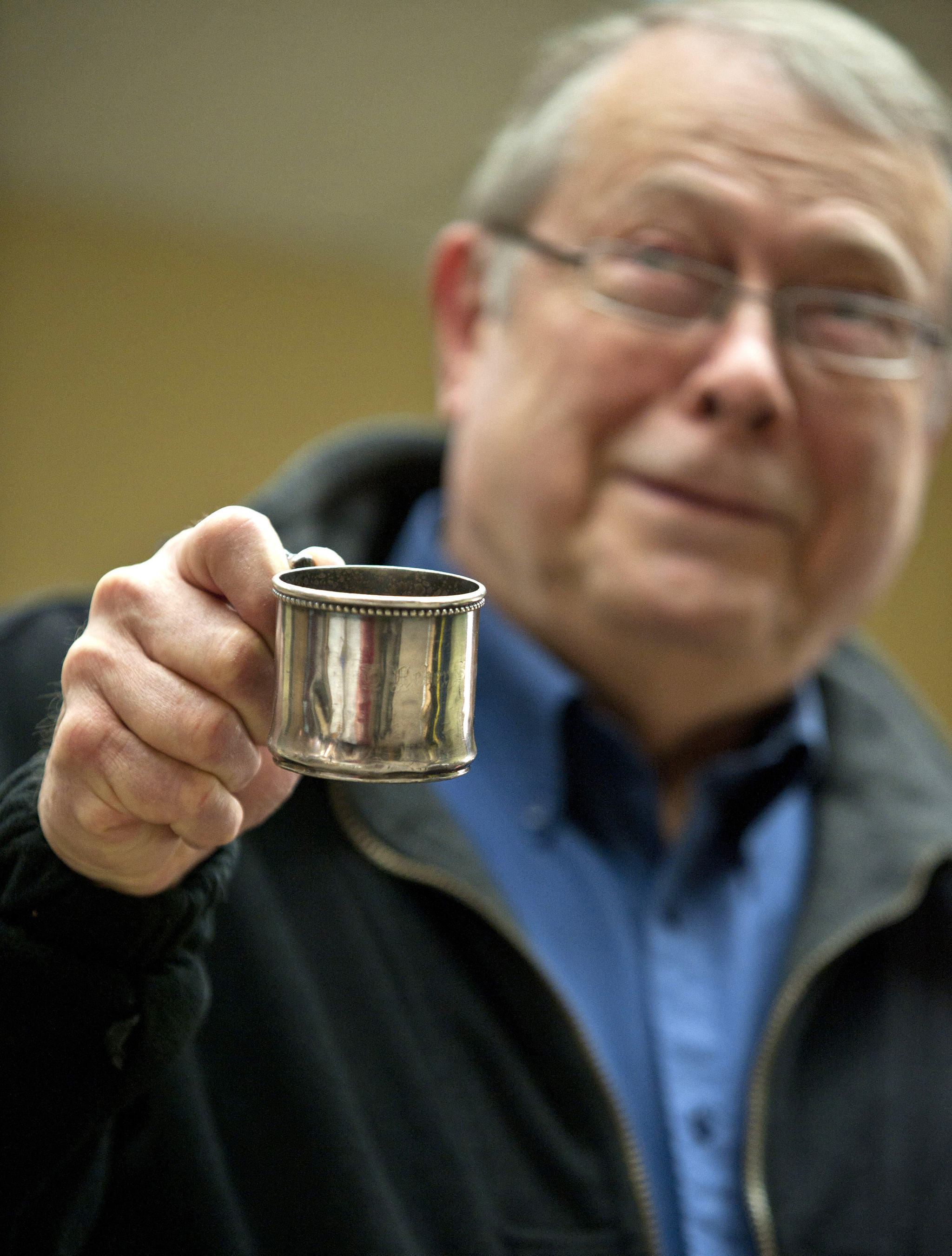 John Stein is shown Feb. 3 in Sitka holding up his father’s baby cup. The cup, believed to be from about 1899, was recently returned to Stein. (James Poulson | Daily Sitka Sentinel)