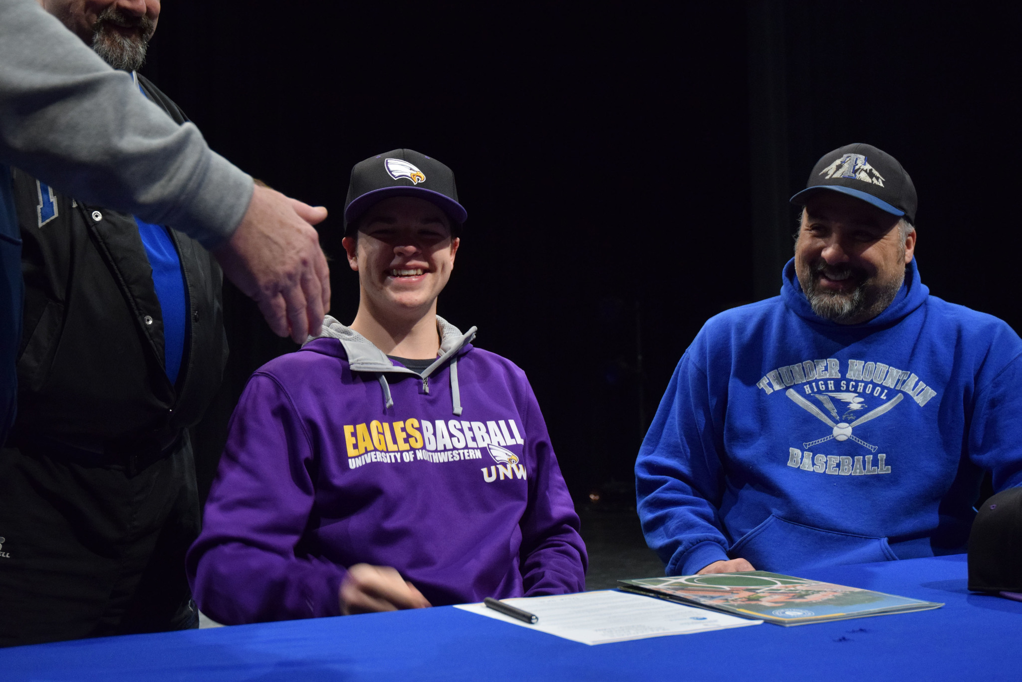 Thunder Mountain pitcher Philip Wall smiles after signing a national letter of intent to play baseball at University of Northwestern-St. Paul on Wednesday in the Thunder Mountain High School auditorium. (Nolin Ainsworth | Juneau Empire)
